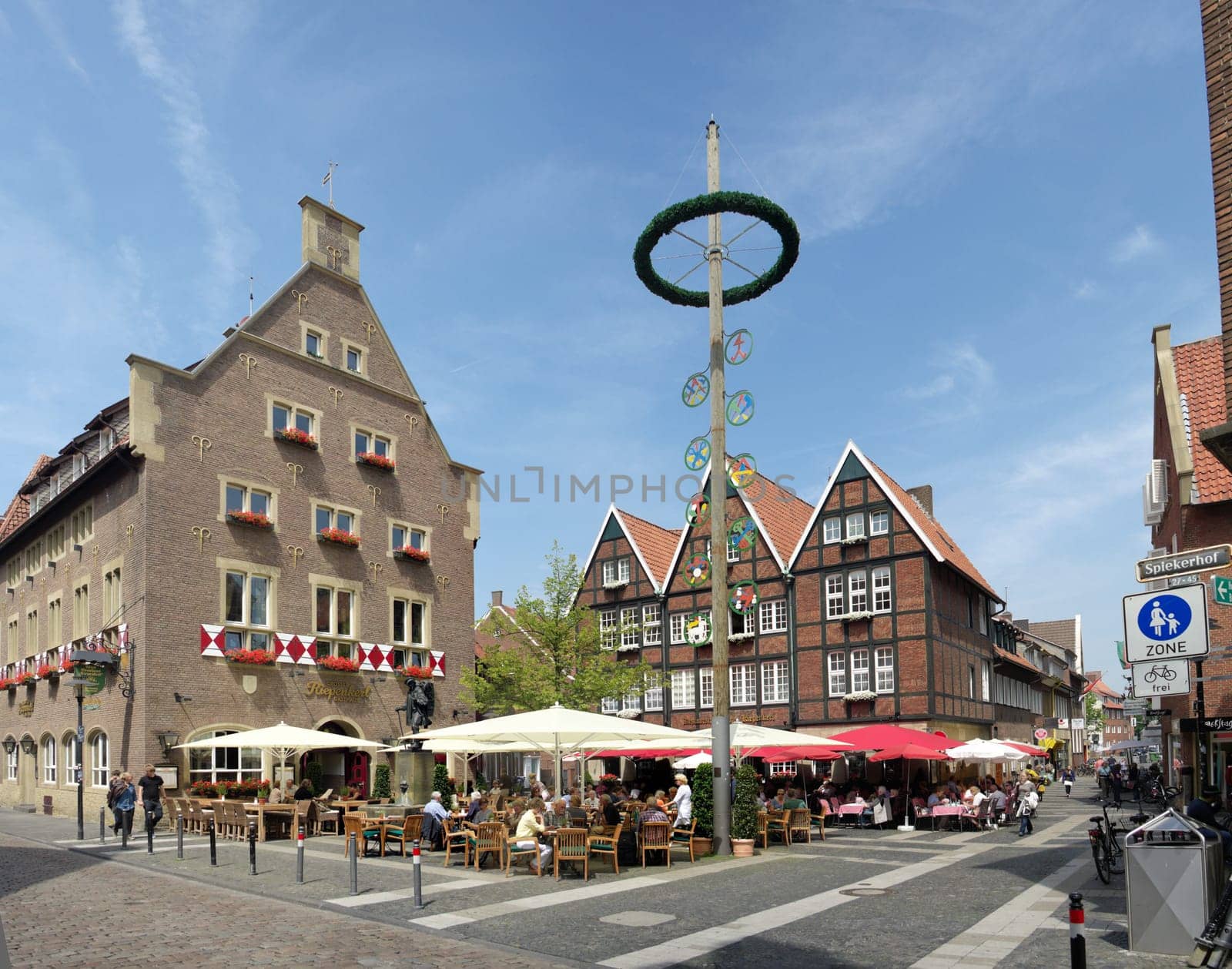 people enjoying the sun on a terrace in the center of Munster, Germany. The city is considered to be the cultural center of the Westphalia region. It is also capital of the local government region Münsterland.