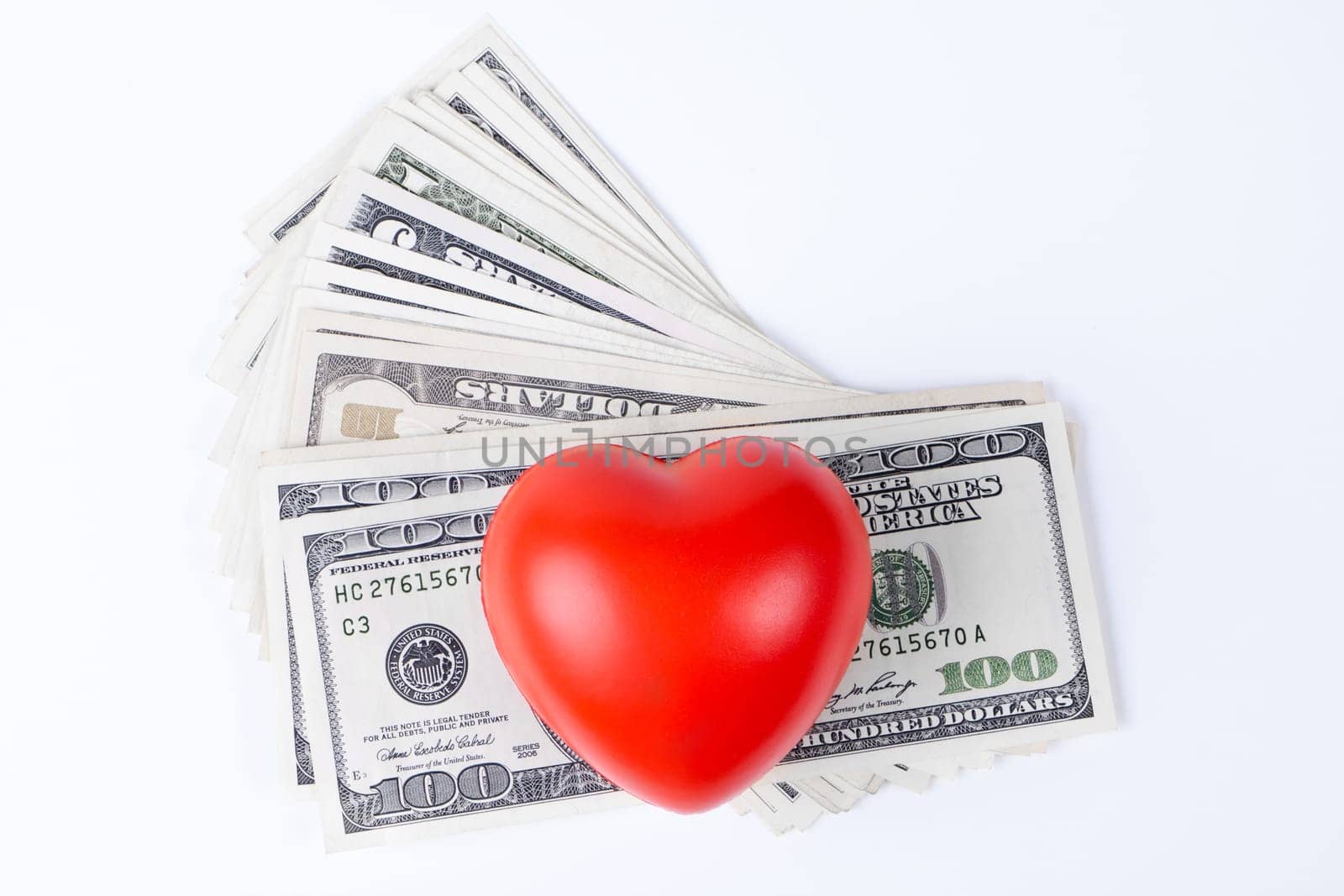 red  heart on top of dollars white background