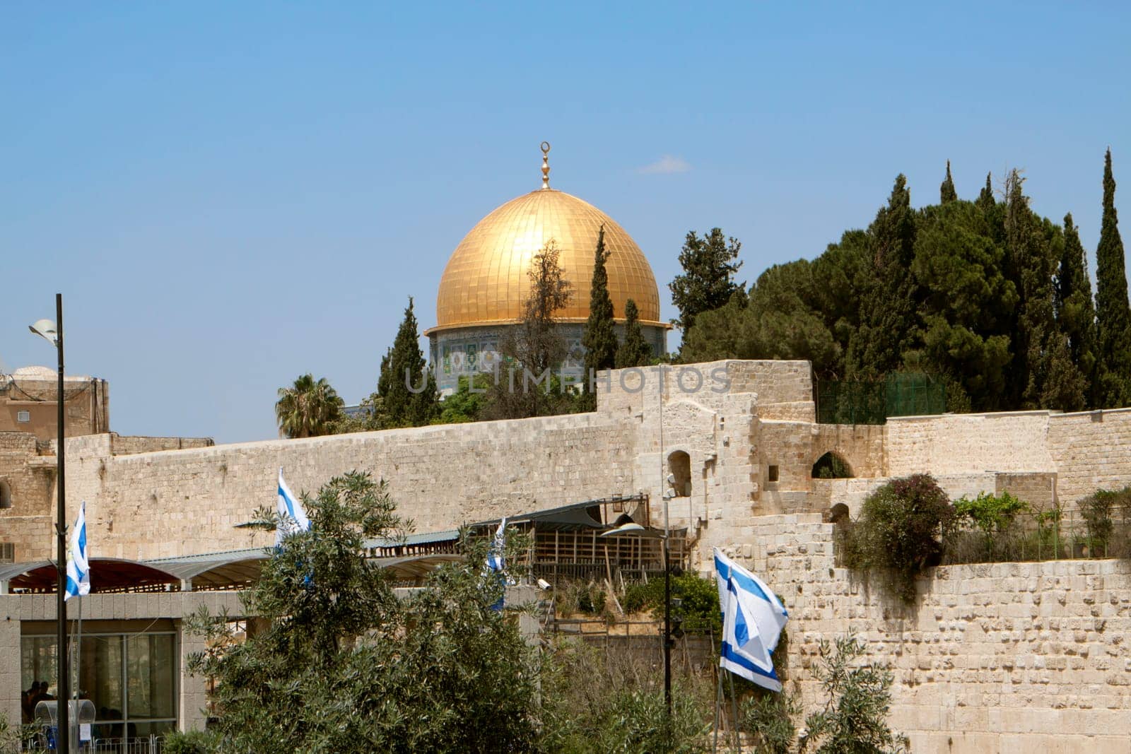golden mosque on top of the wailing wall in jerusalem with israeli flags
