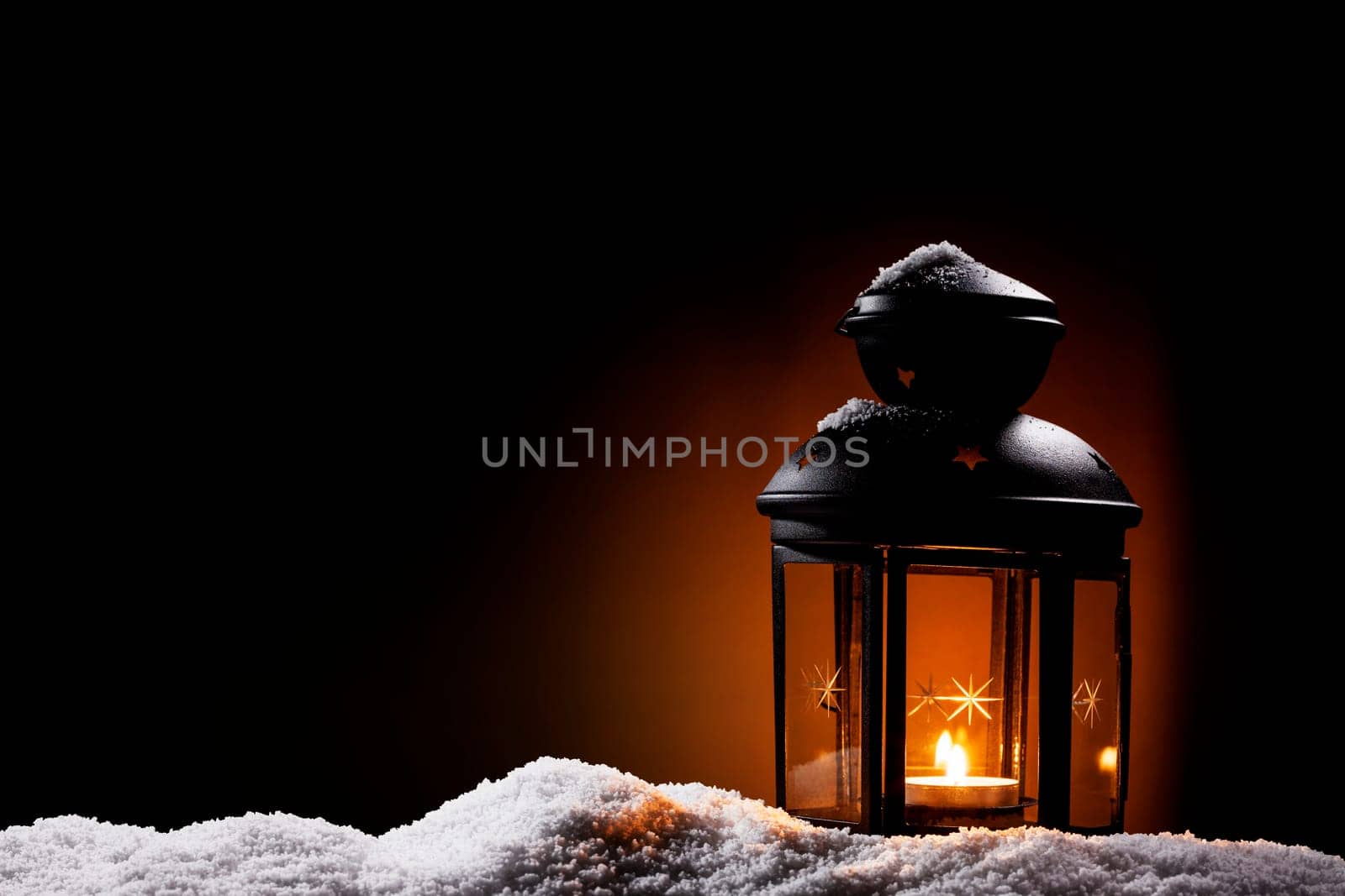 Lantern in the dark stands in the snow