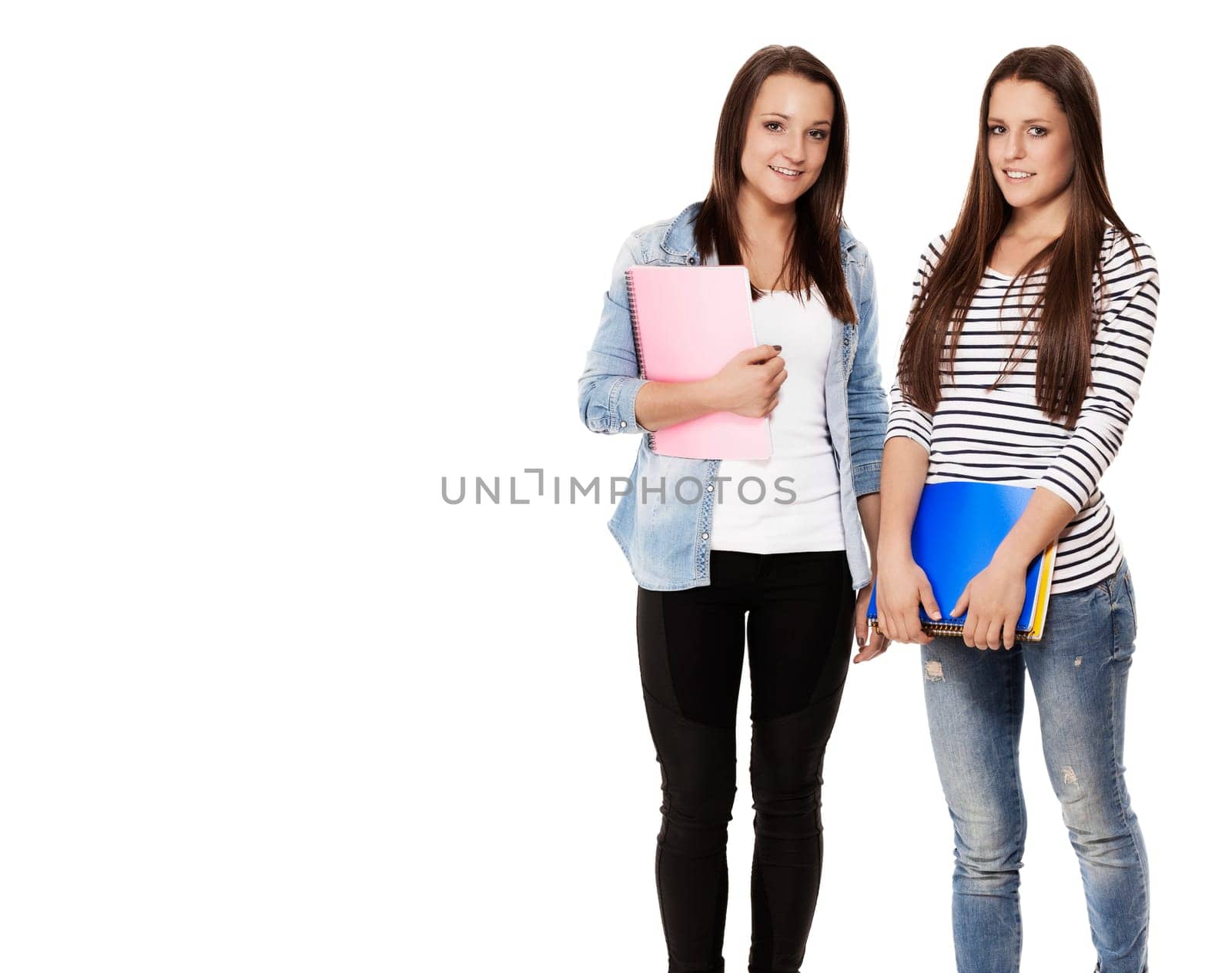 Two pretty schoolgirls with notepads against white background