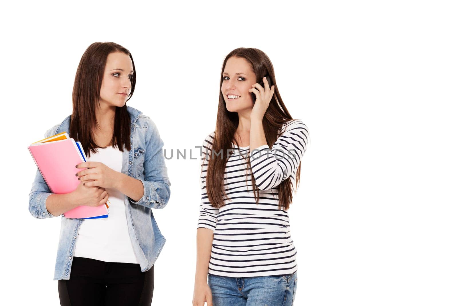 Two students with notepads talking on the phone against white background