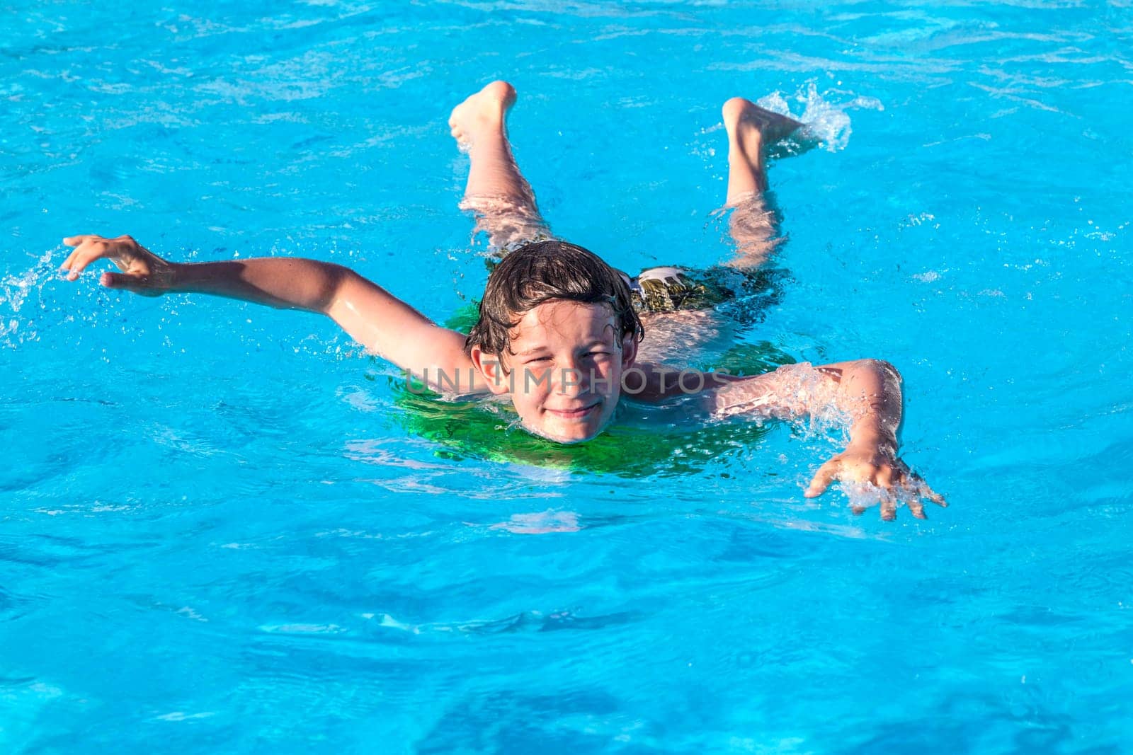 cute boy relaxing on a surfboard in the pool