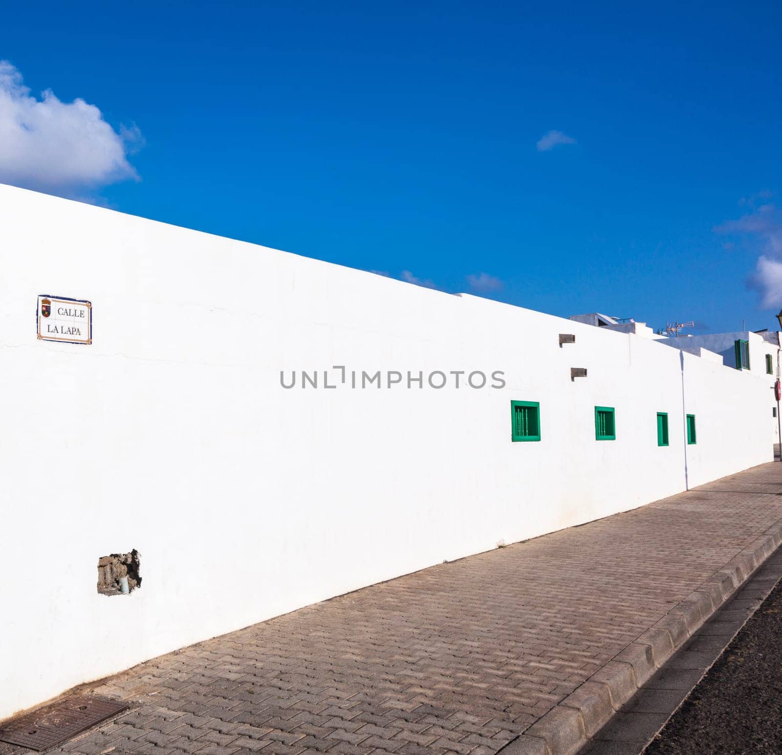 facade of mediterranean house with closed shutterblinds at midday