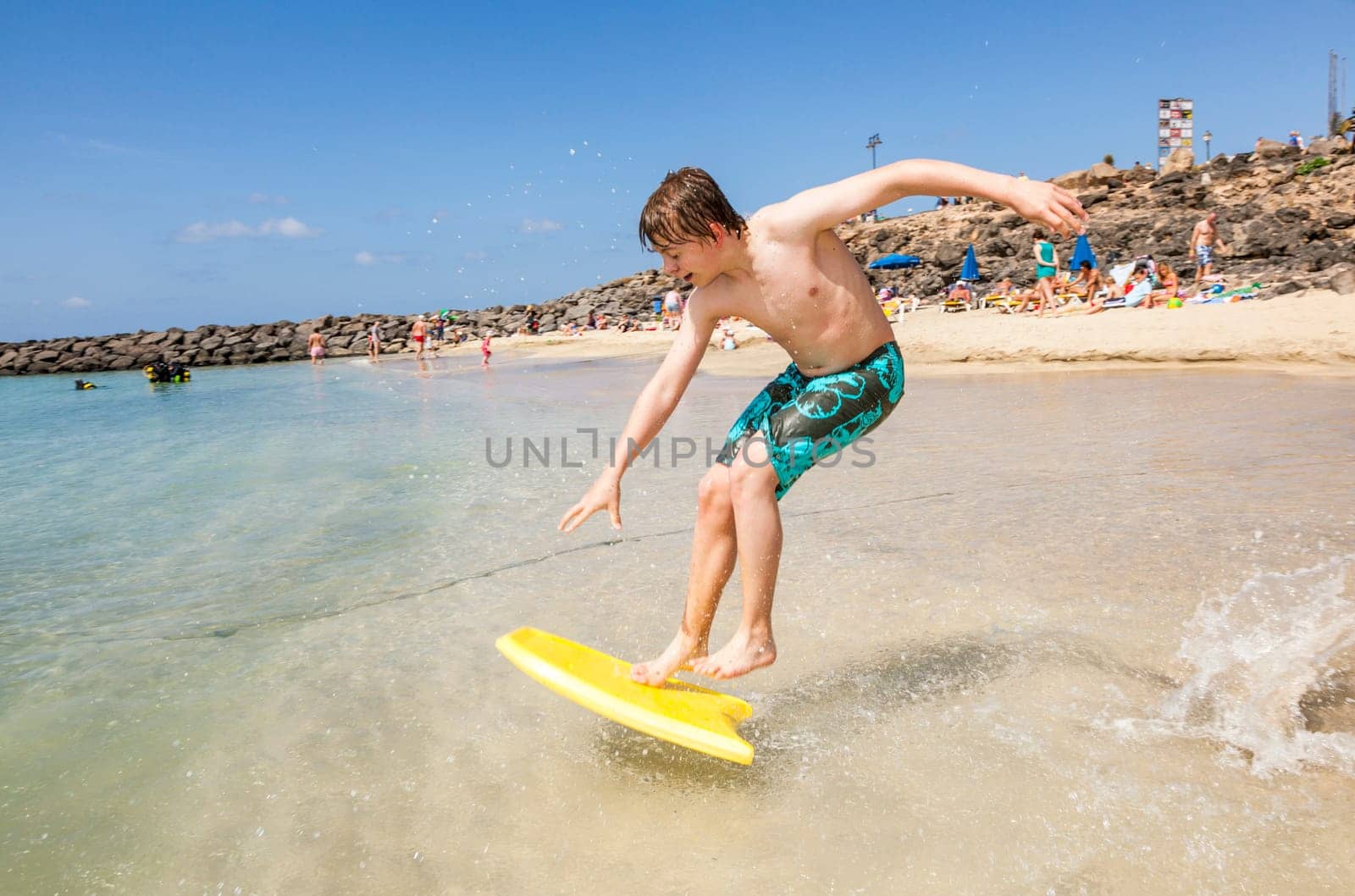 happy boy enjoys surfing in the waves at the beach