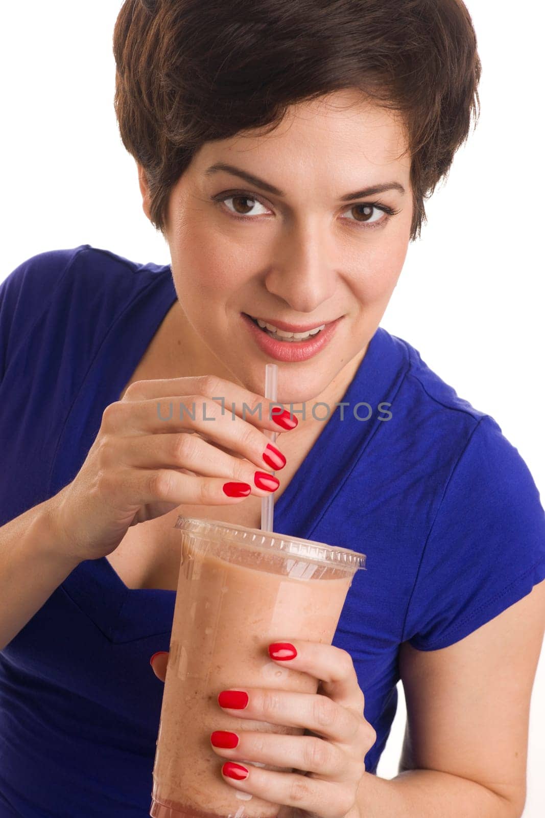 Beautiful woman with manicured nails sips a green smoothie