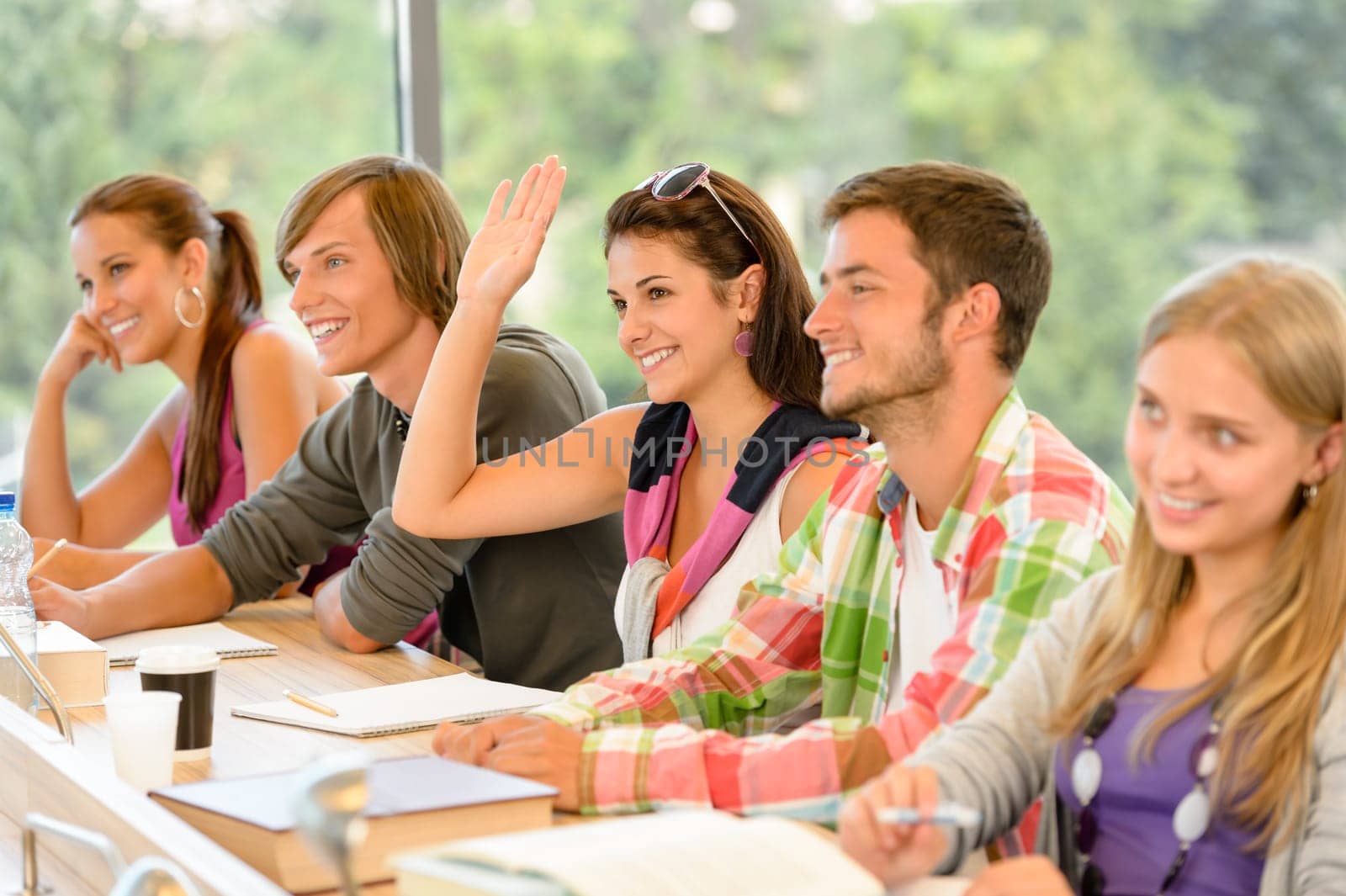 High-school student raising her hand in class lesson teenagers study