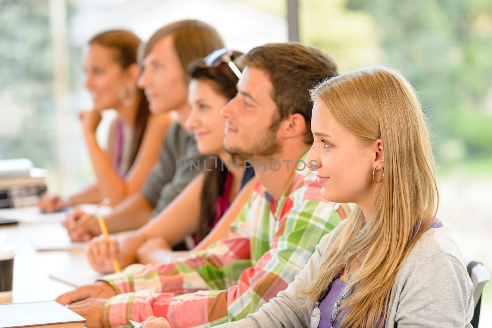 High-school students listening to lesson in class campus college teens
