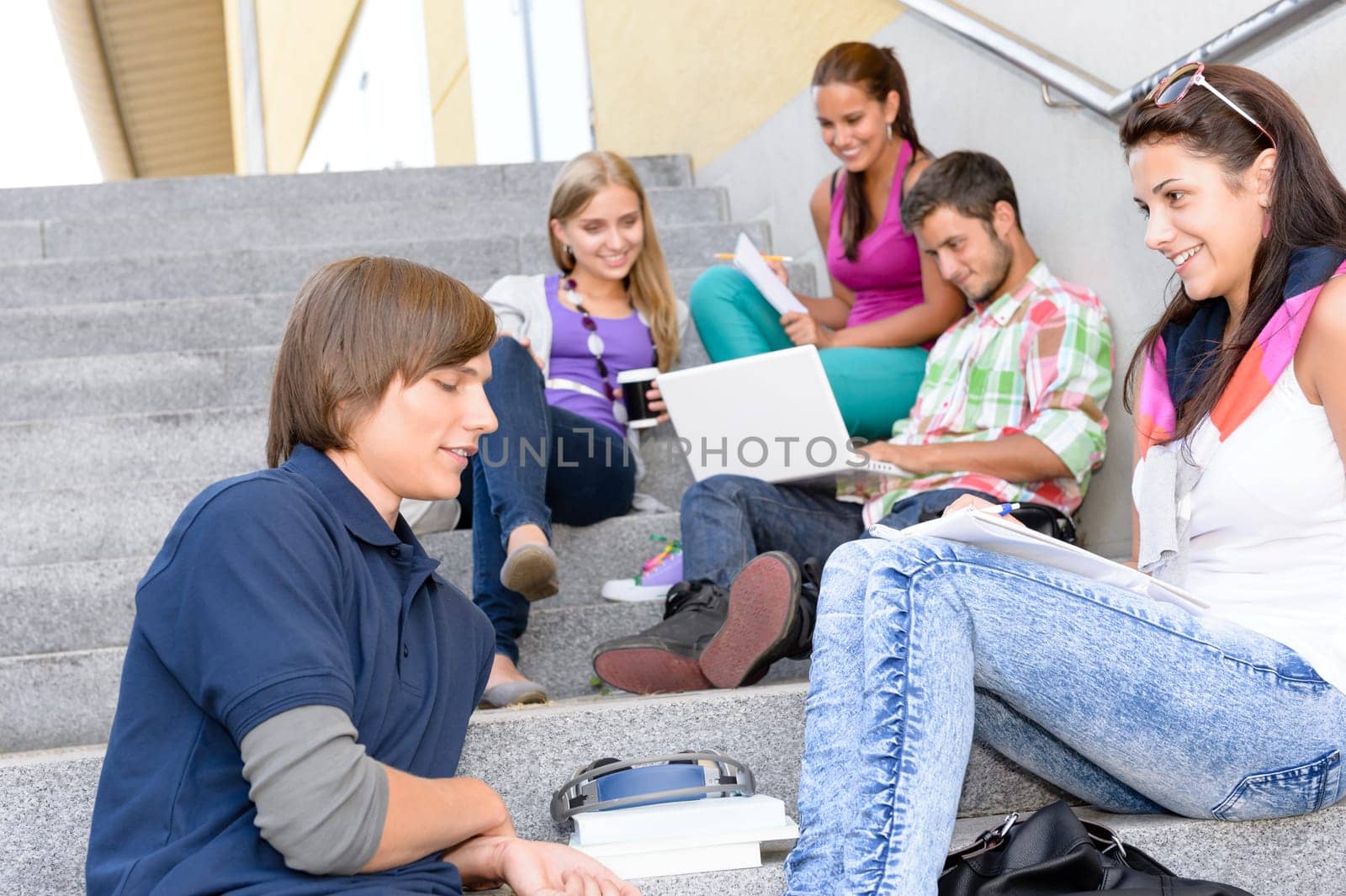 Students relaxing on high-school steps in break teens young college