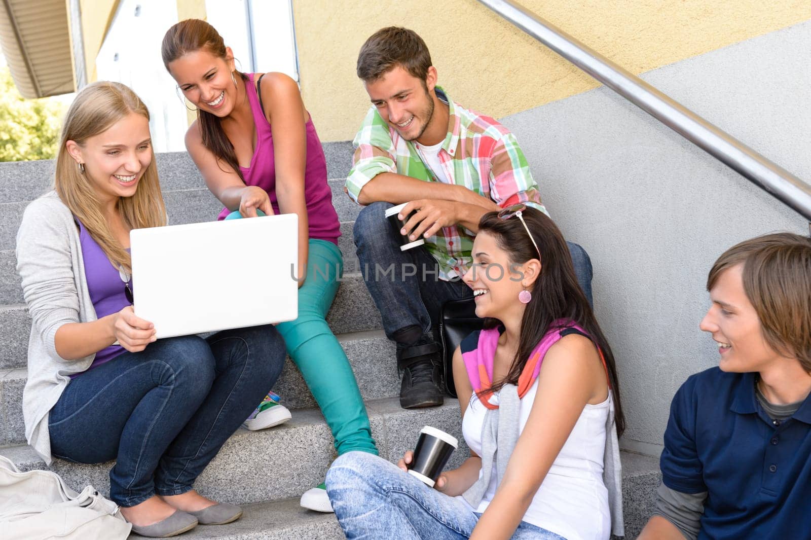 Students having fun with laptop school stairs teens college laughing