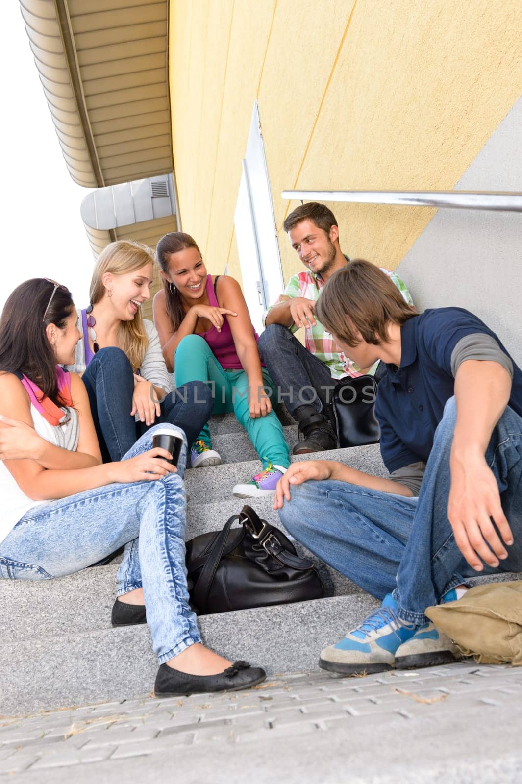 Students laughing on school stairs in break teens college relaxing