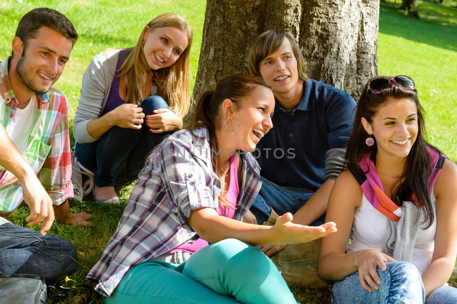 Students relaxing in schoolyard teens meadow park laughing campus young