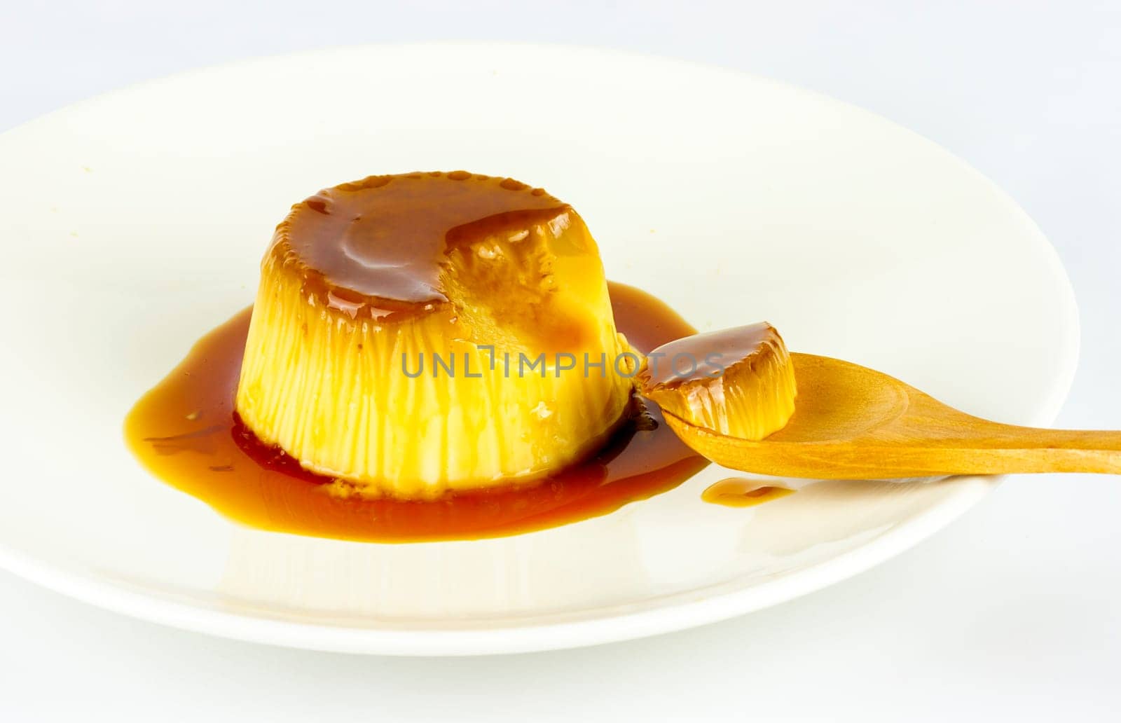 Delicious vanilla cream, egg custard with caramel sauce, and spoon