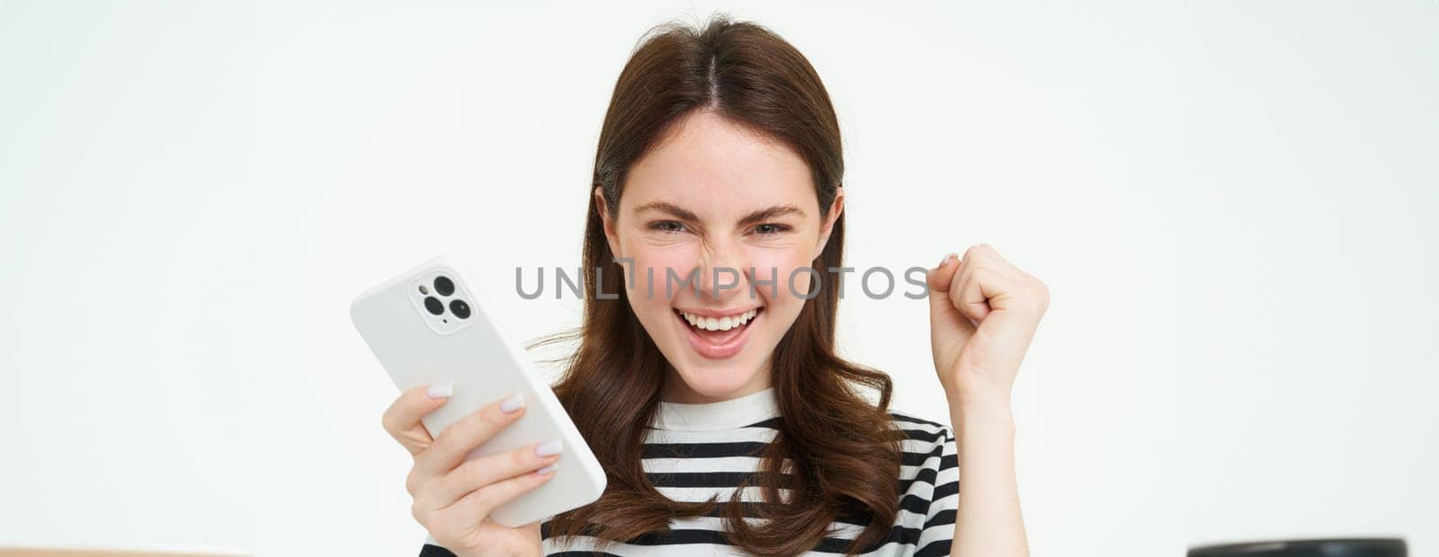 Girl is a champion, Young happy woman laughing and smiling, celebrating victory, winning, holding smartphone and triumphing.