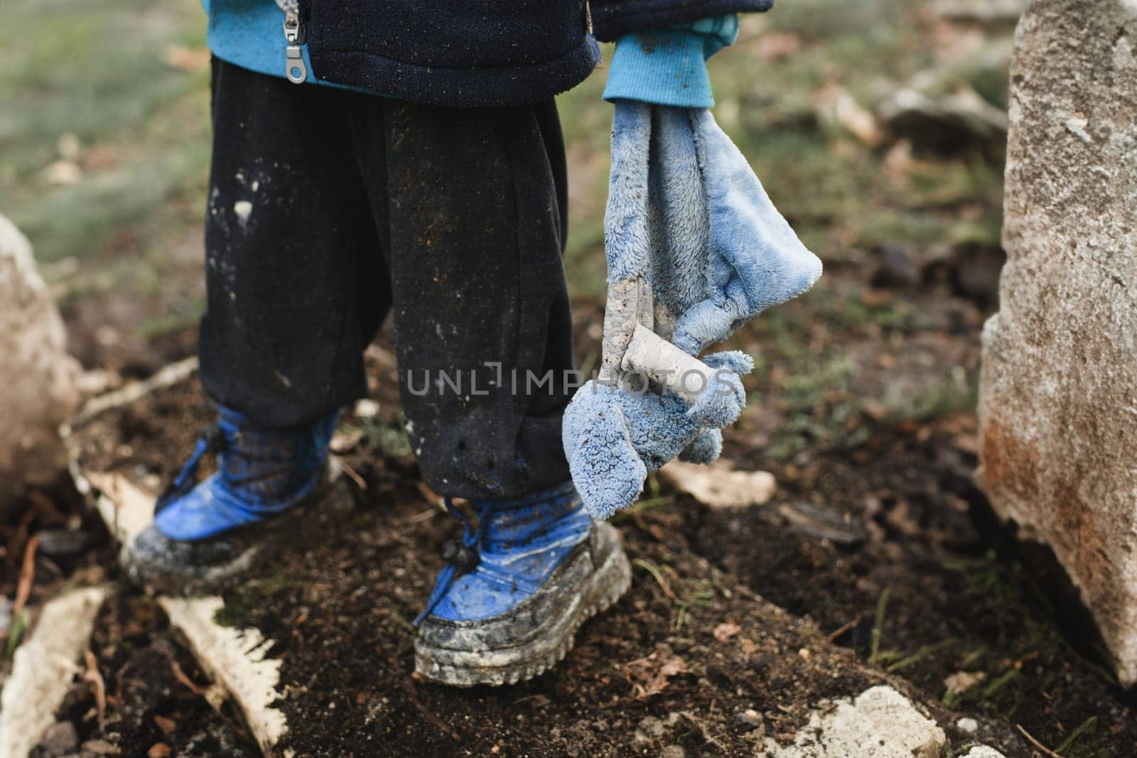 A child with his toy at war after bombardment