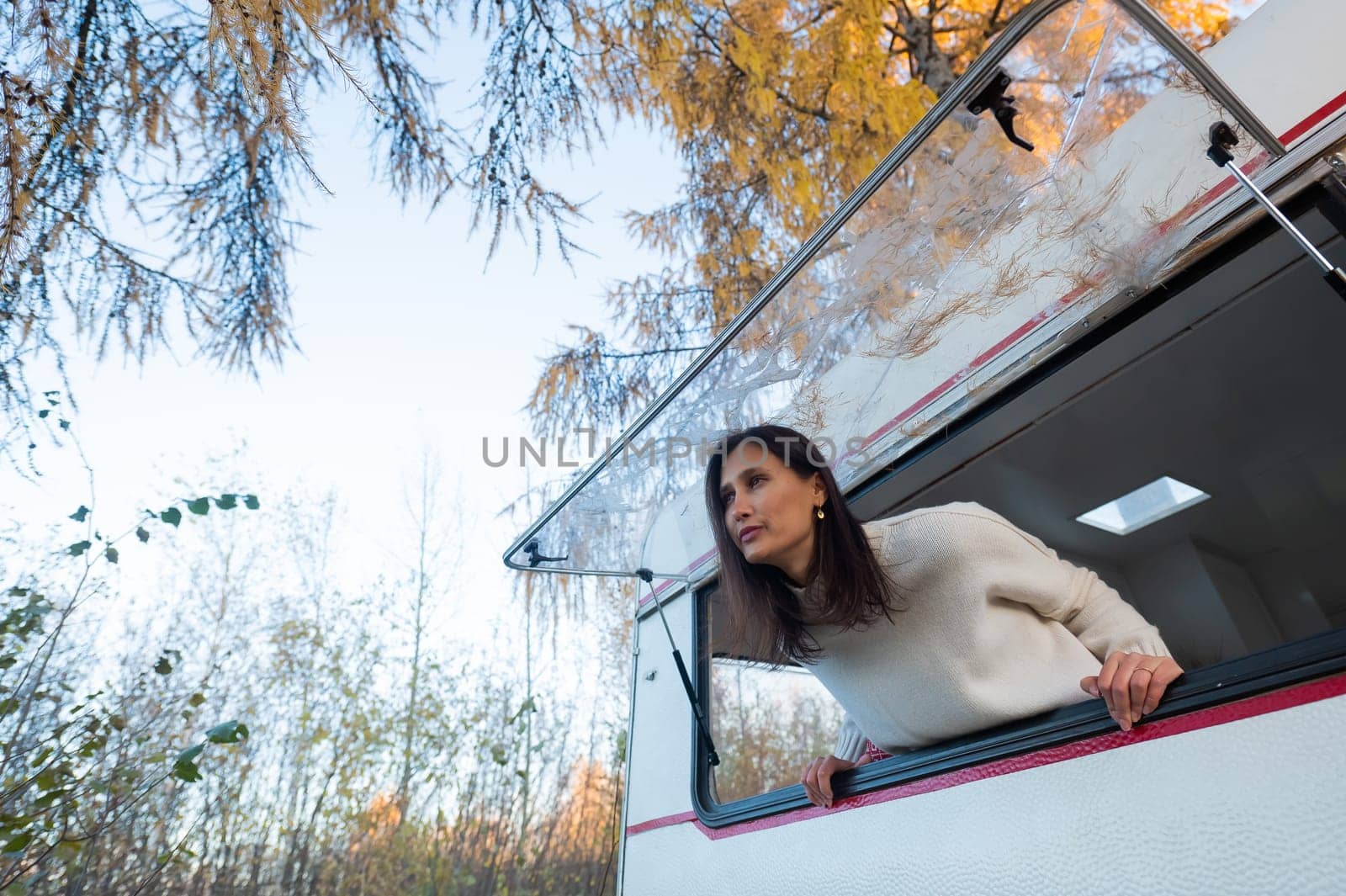 Caucasian woman peeking out of camper window