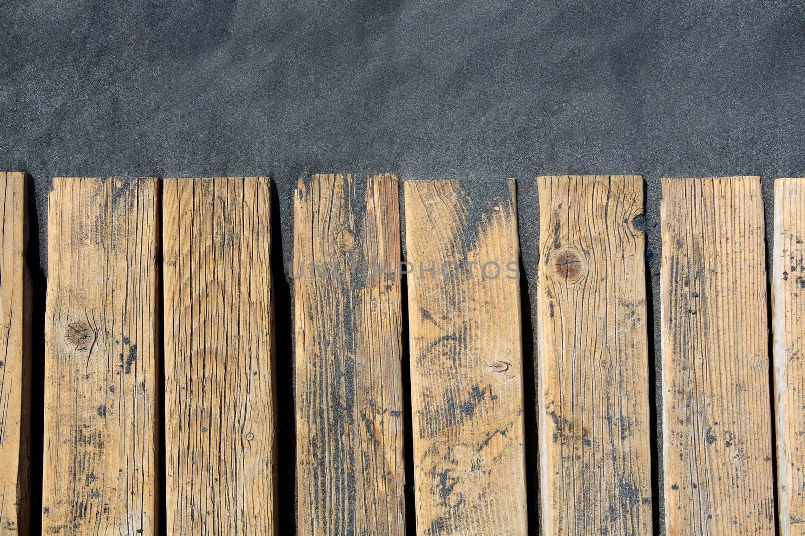 Black beach sand and wooden floor in volcanic Canary Islands