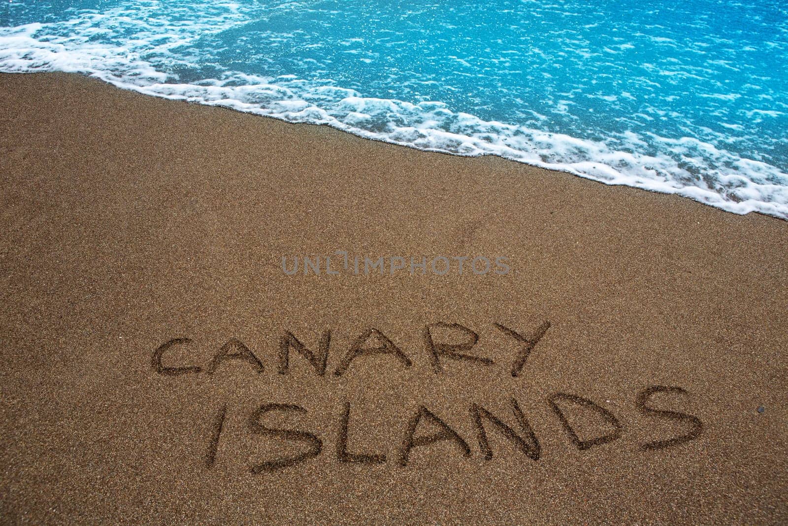 Brown beach sand with written word Canary islands
