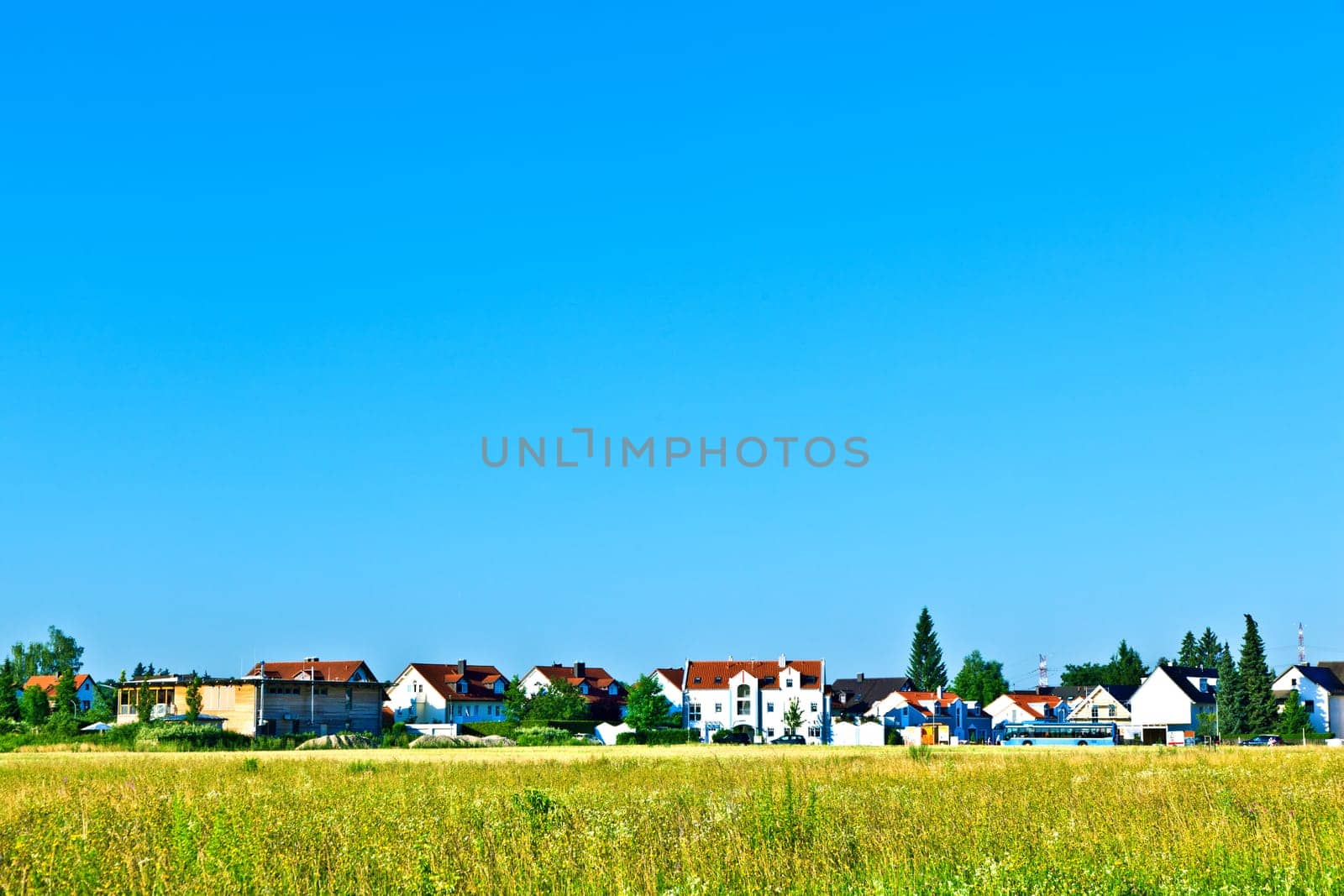 settlement in rural area with fields under blue sky