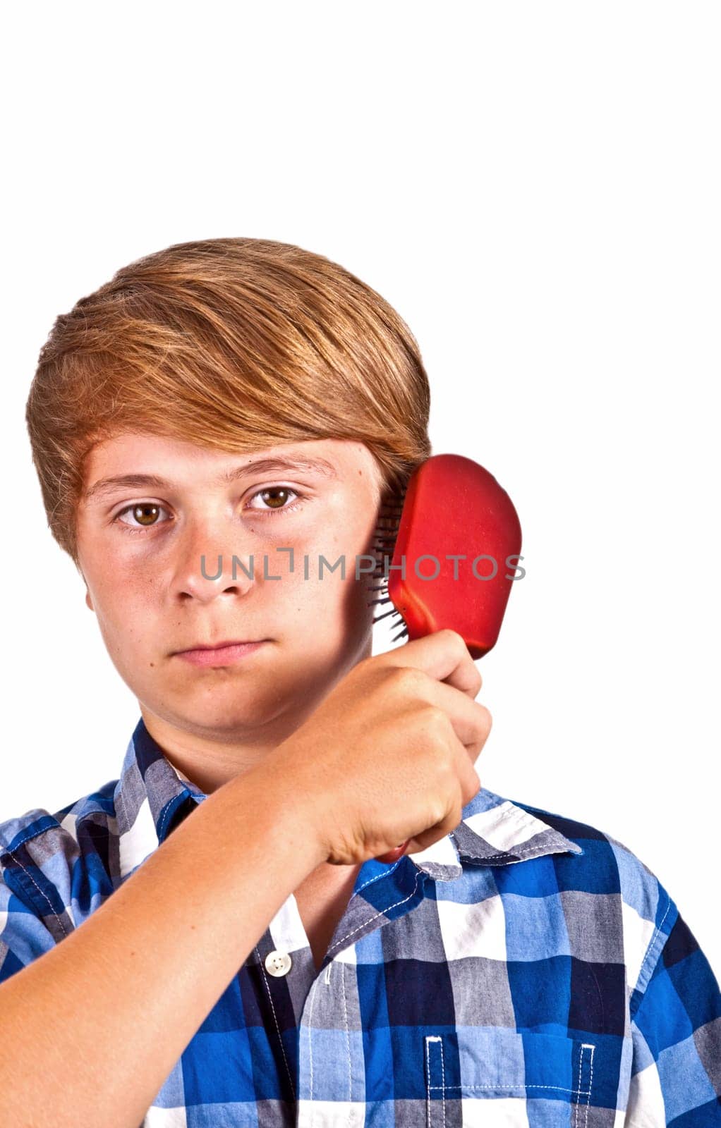 young boy brushing his hair