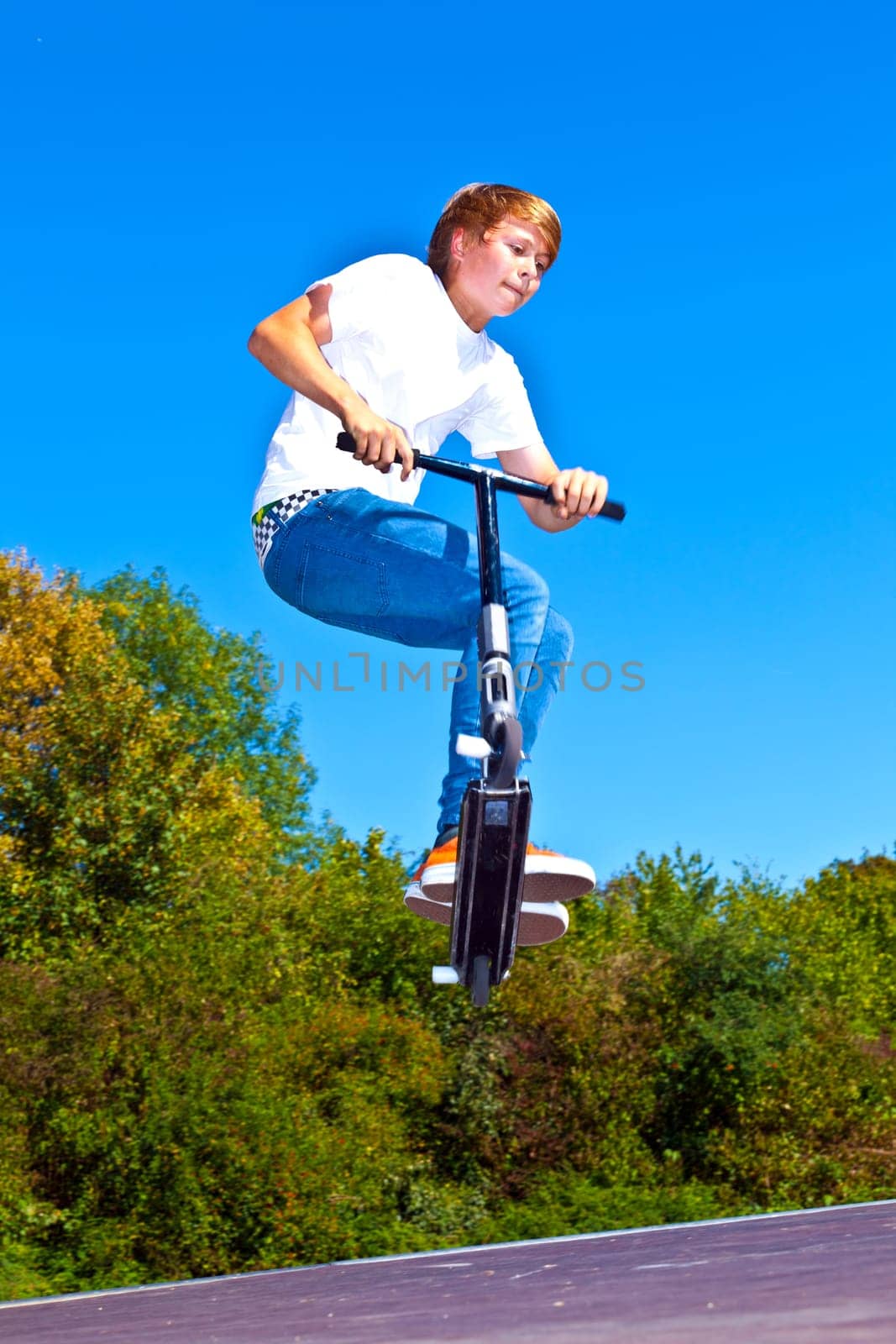 boy jumping with his scooter