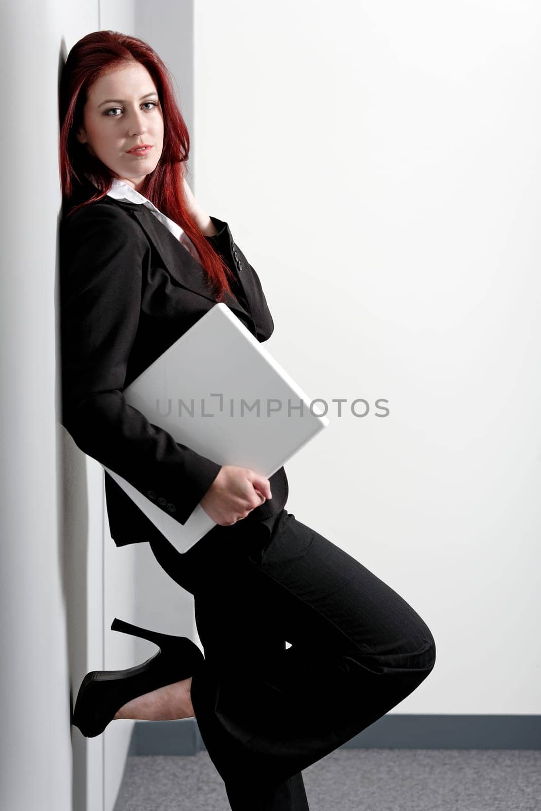 Professional business woman holding a white laptop at work