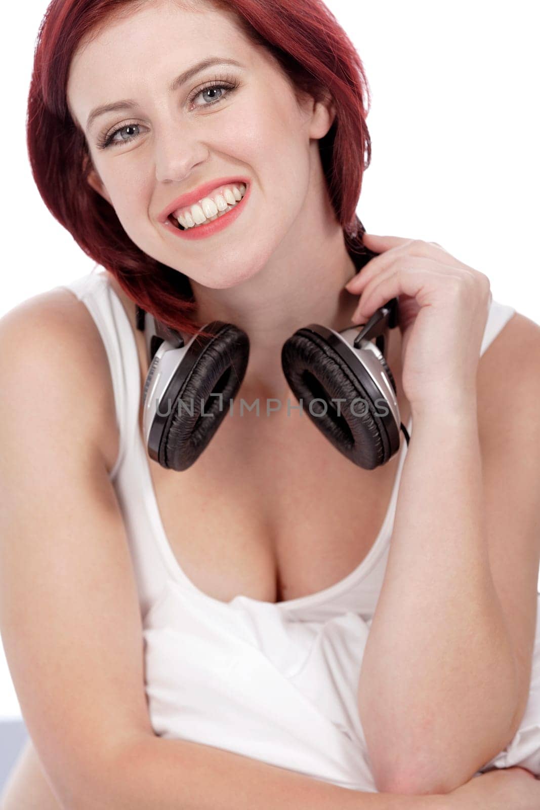 Attractive young woman listening to music at home on her bed
