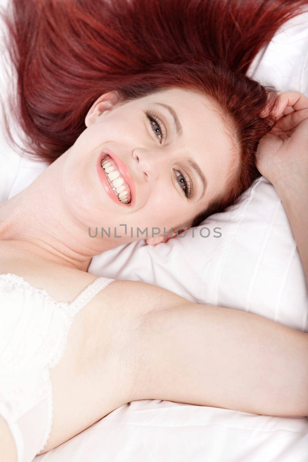 Attractive young woman lying on her bed in her underwear at home