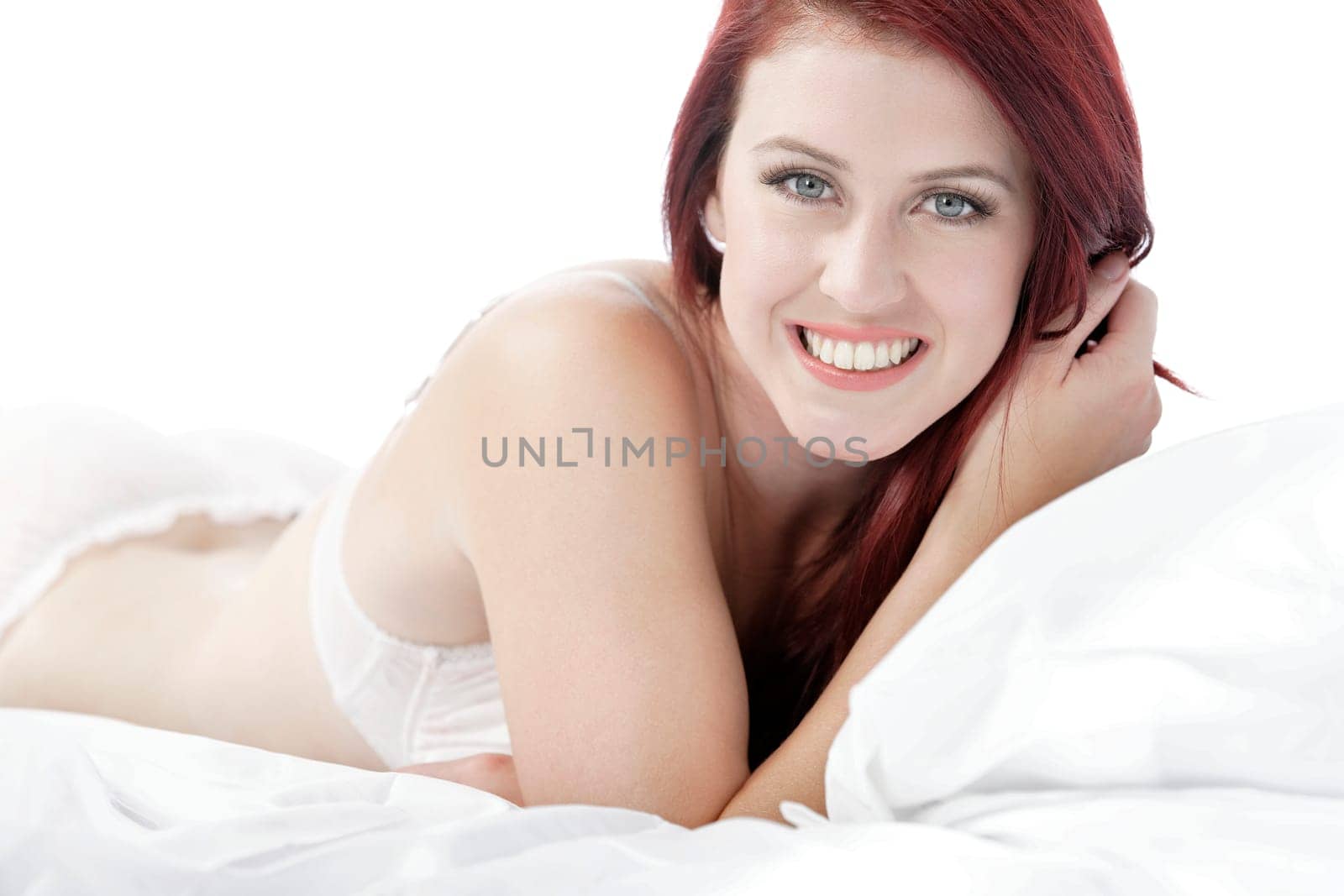 Beautiful young woman resting on her bed at home in her underwear