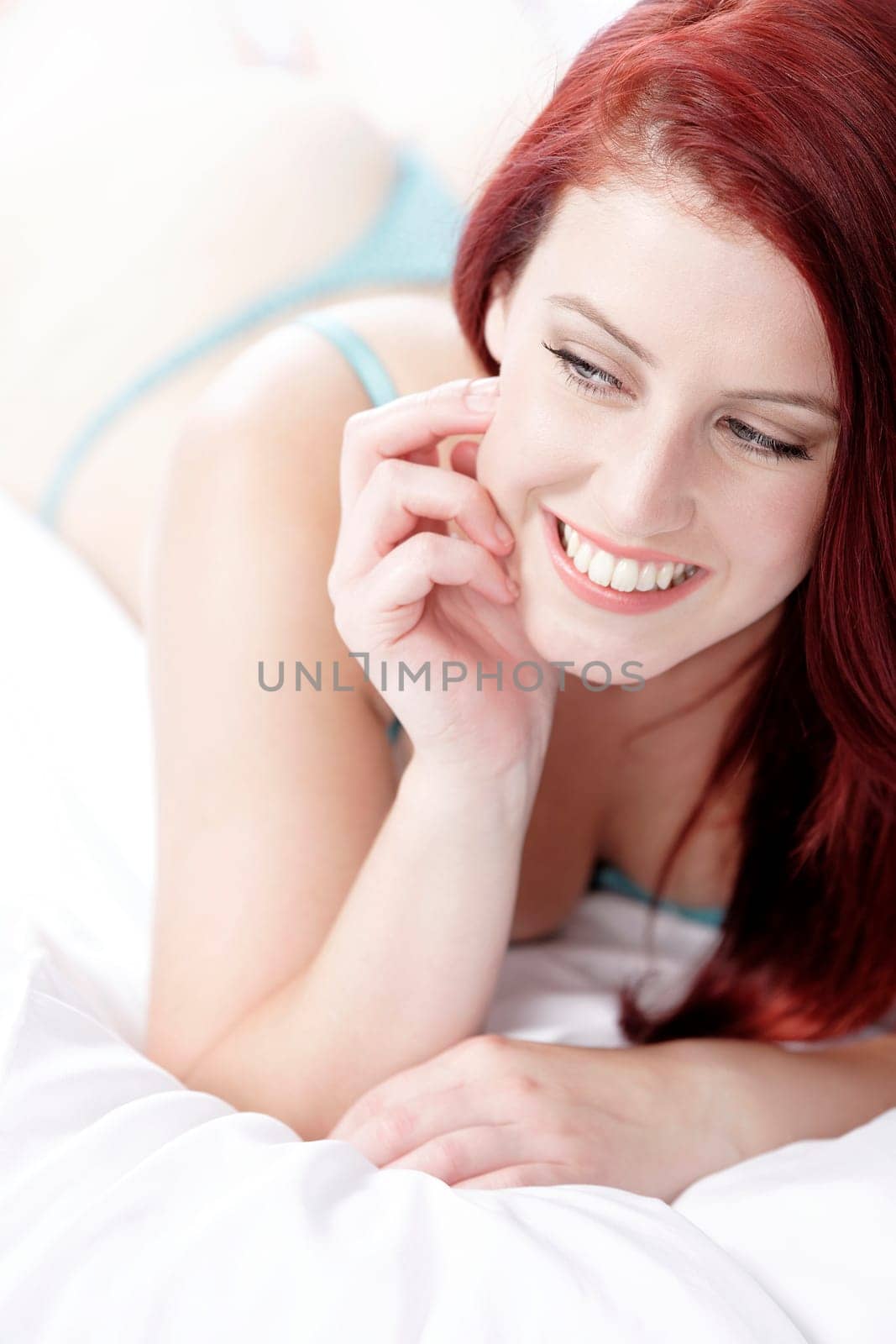 Beautiful young woman resting on her bed at home in her underwear