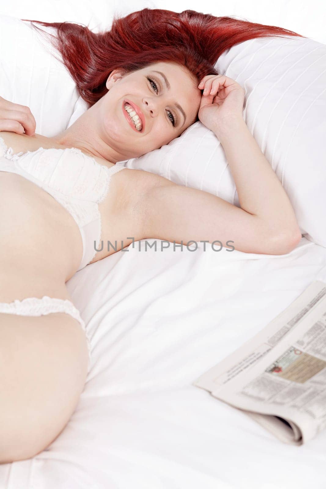 Attractive young woman lying on her bed in her underwear at home