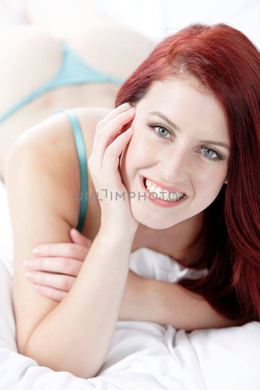 Beautiful young woman resting on her bed at home in her underwear
