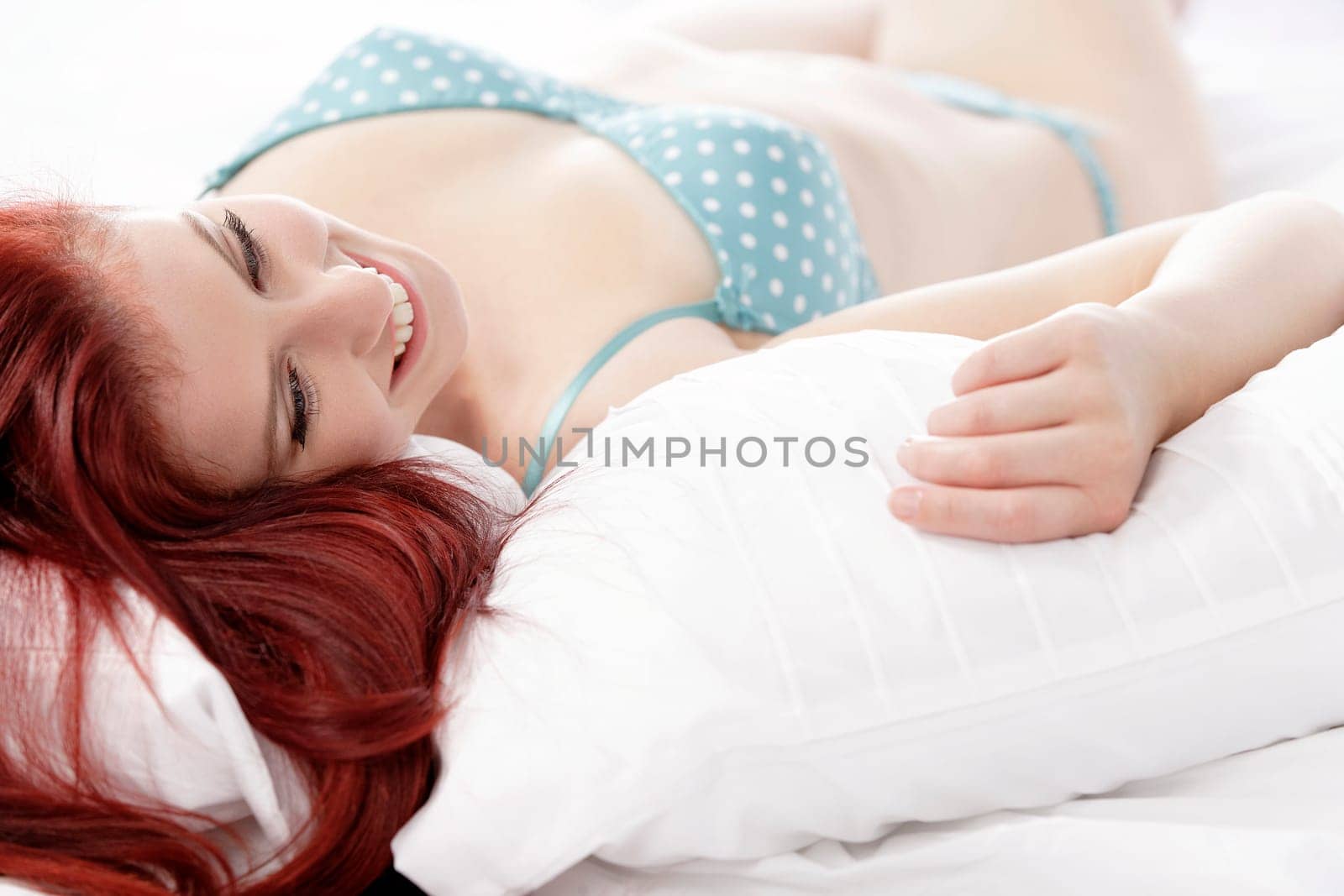 Beautiful young woman resting on her bed at home in her underwear
