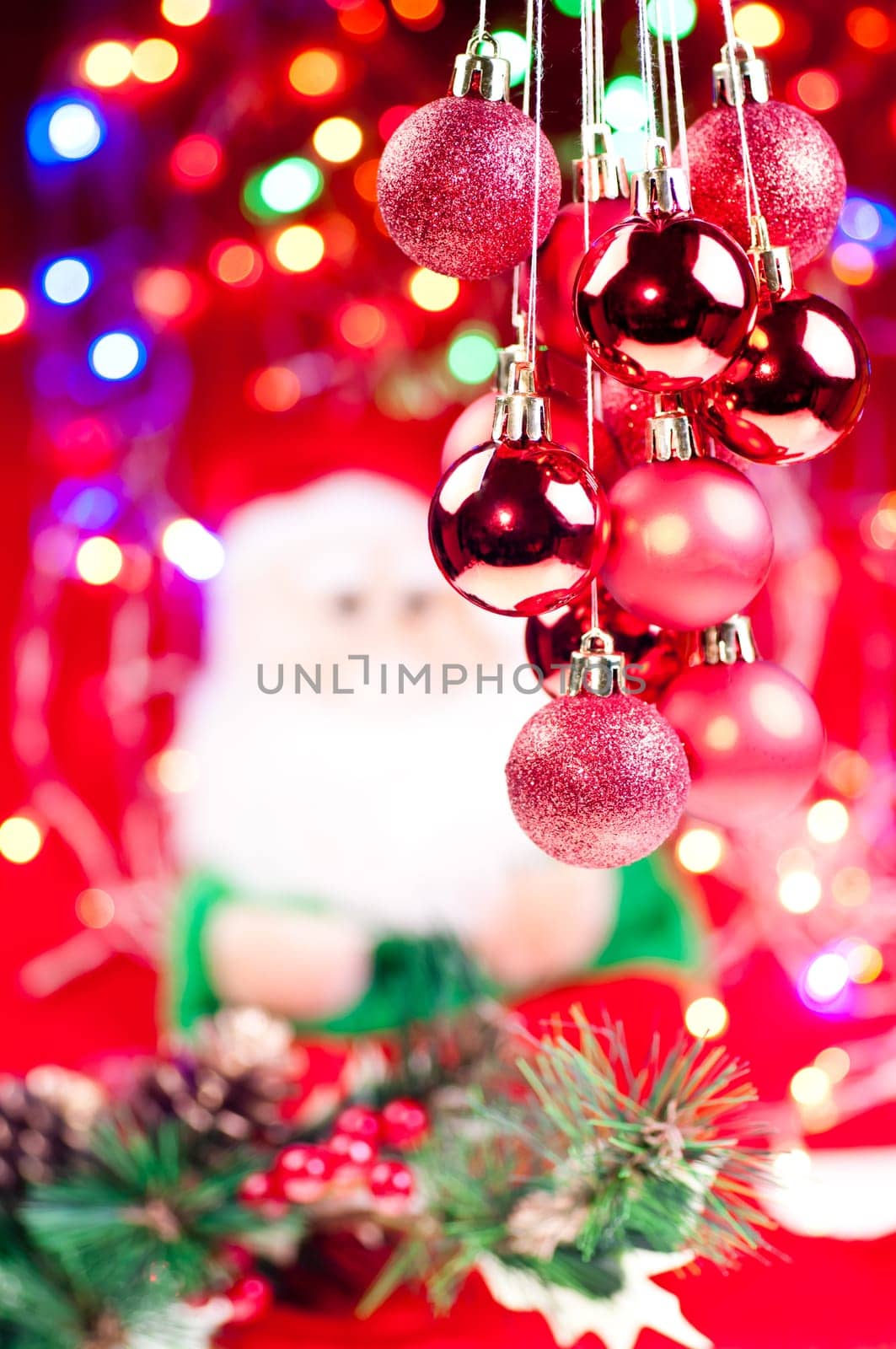 Red Christmas hanging baubles with santa , lights, and decorations at the background