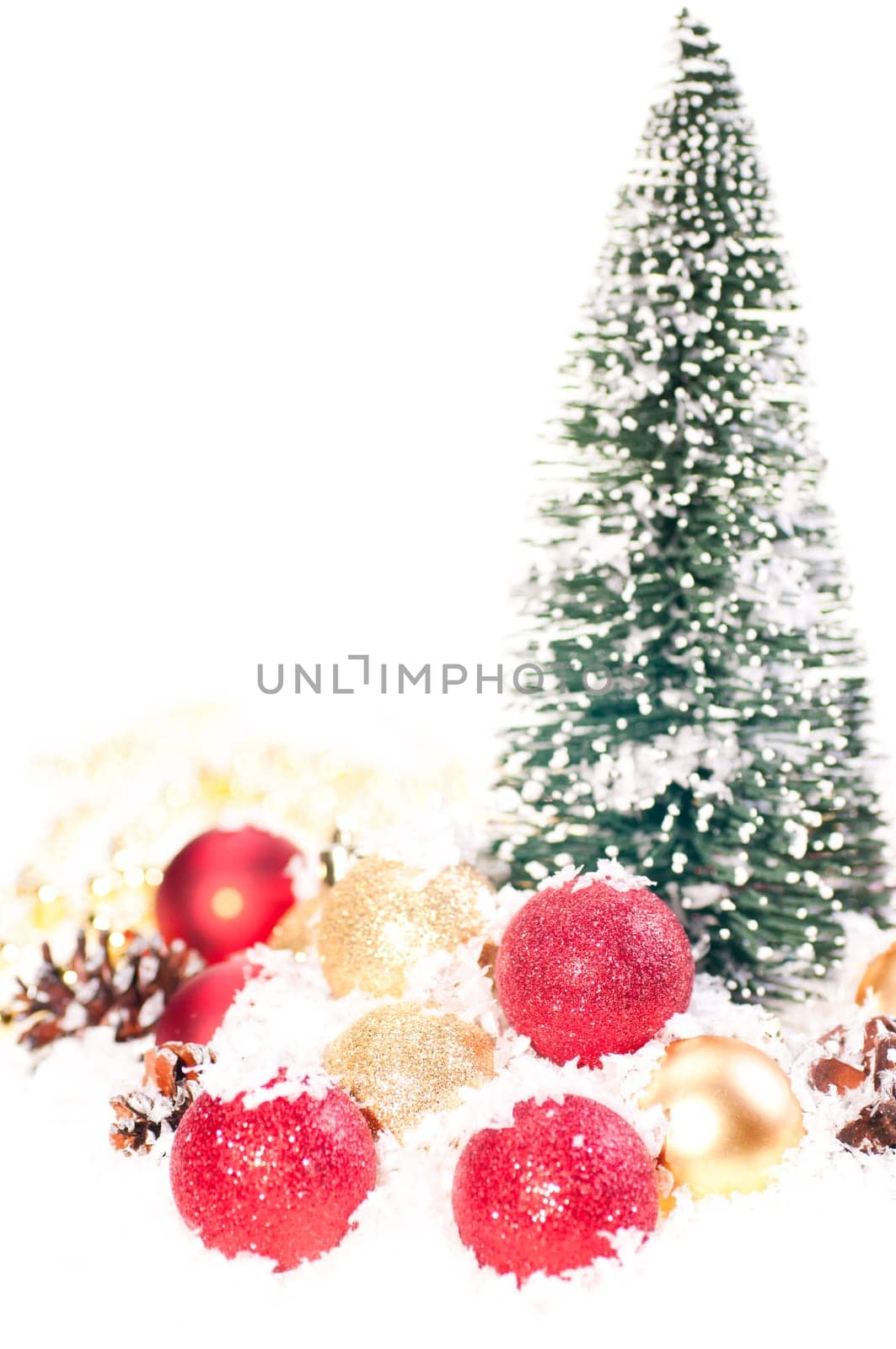 Mini Christmas tree with pinecones on snow and red and gold baubles
