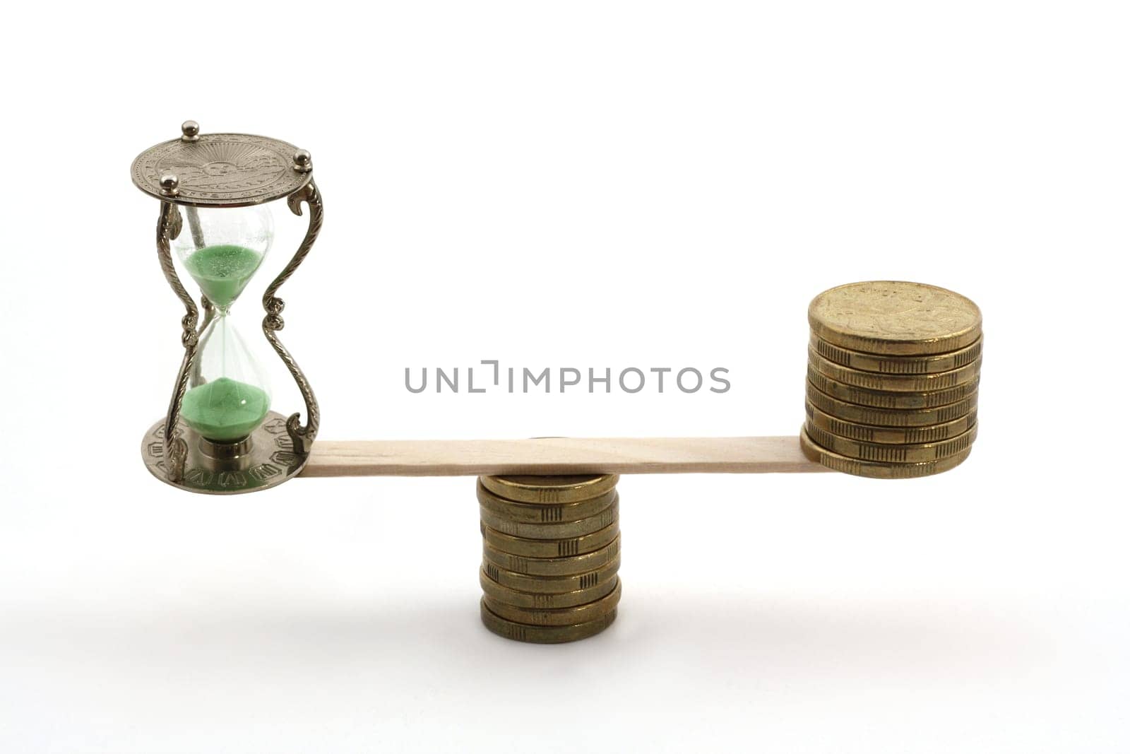 "Time is money"" concept. An hourglass in the balance with several dollar coins."
