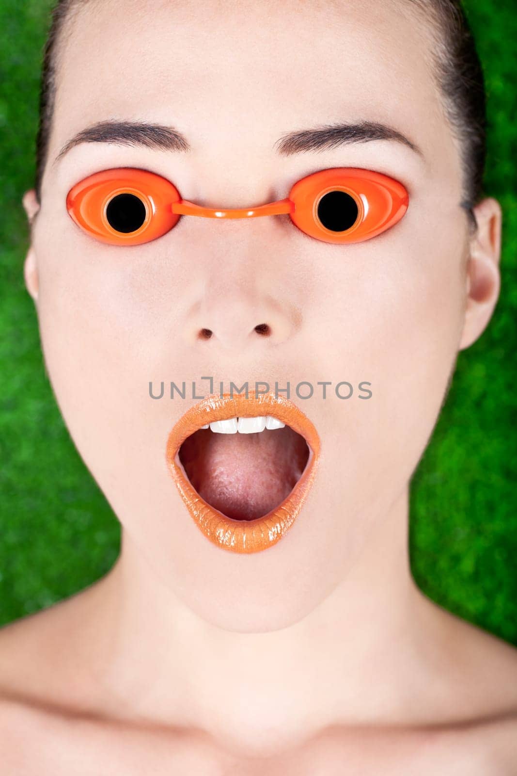 Closeup portrait of a surprised beautiful woman wearing tanning bed glasses with mouth open