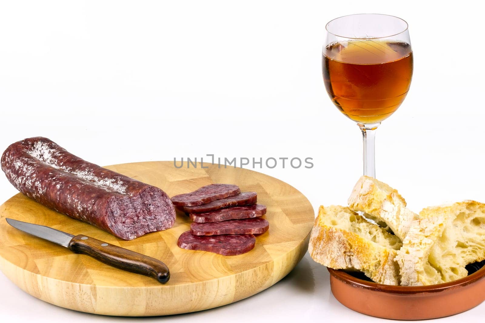 Iberian sausage sausage on a wooden board, with a glass of wine, and sliced ??rustic bread.