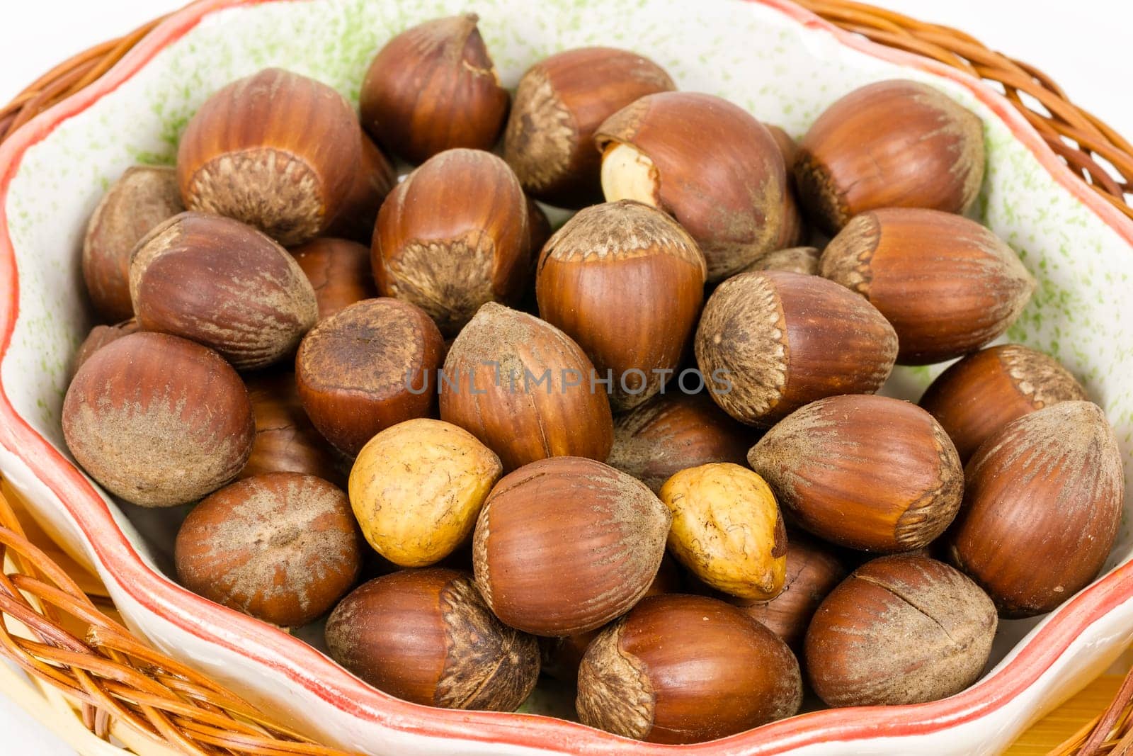 hazelnuts in a basket, isolated on white background