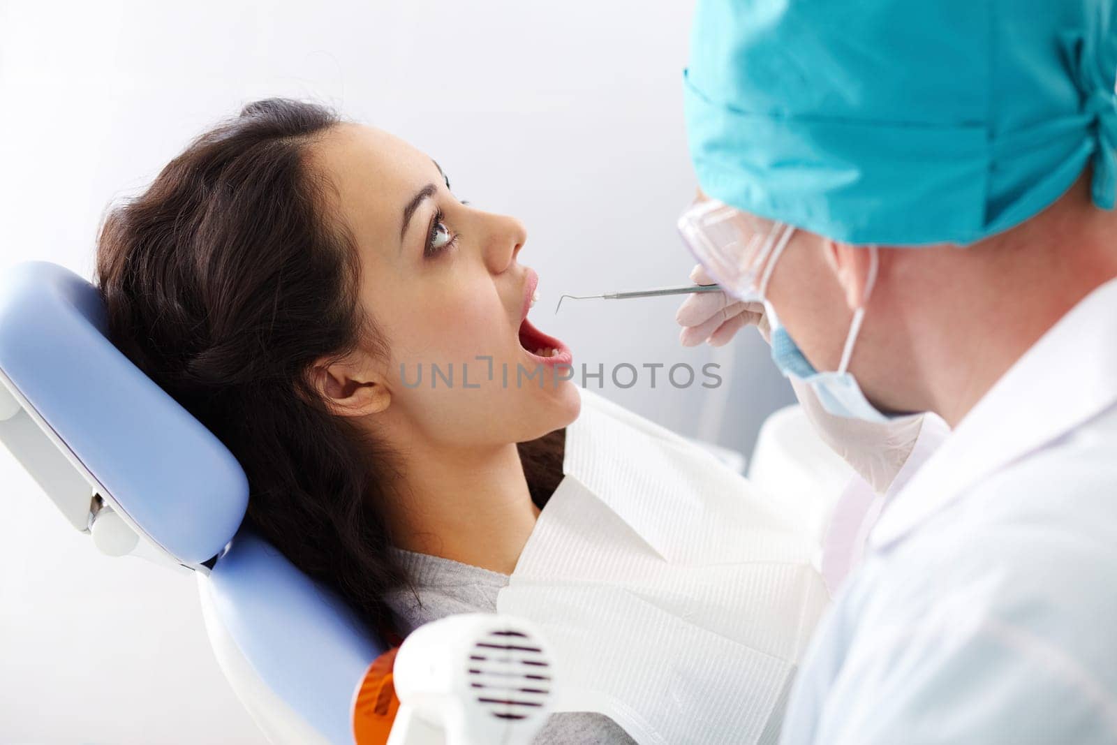 A female patient sitting in the dental chair with her mouth open