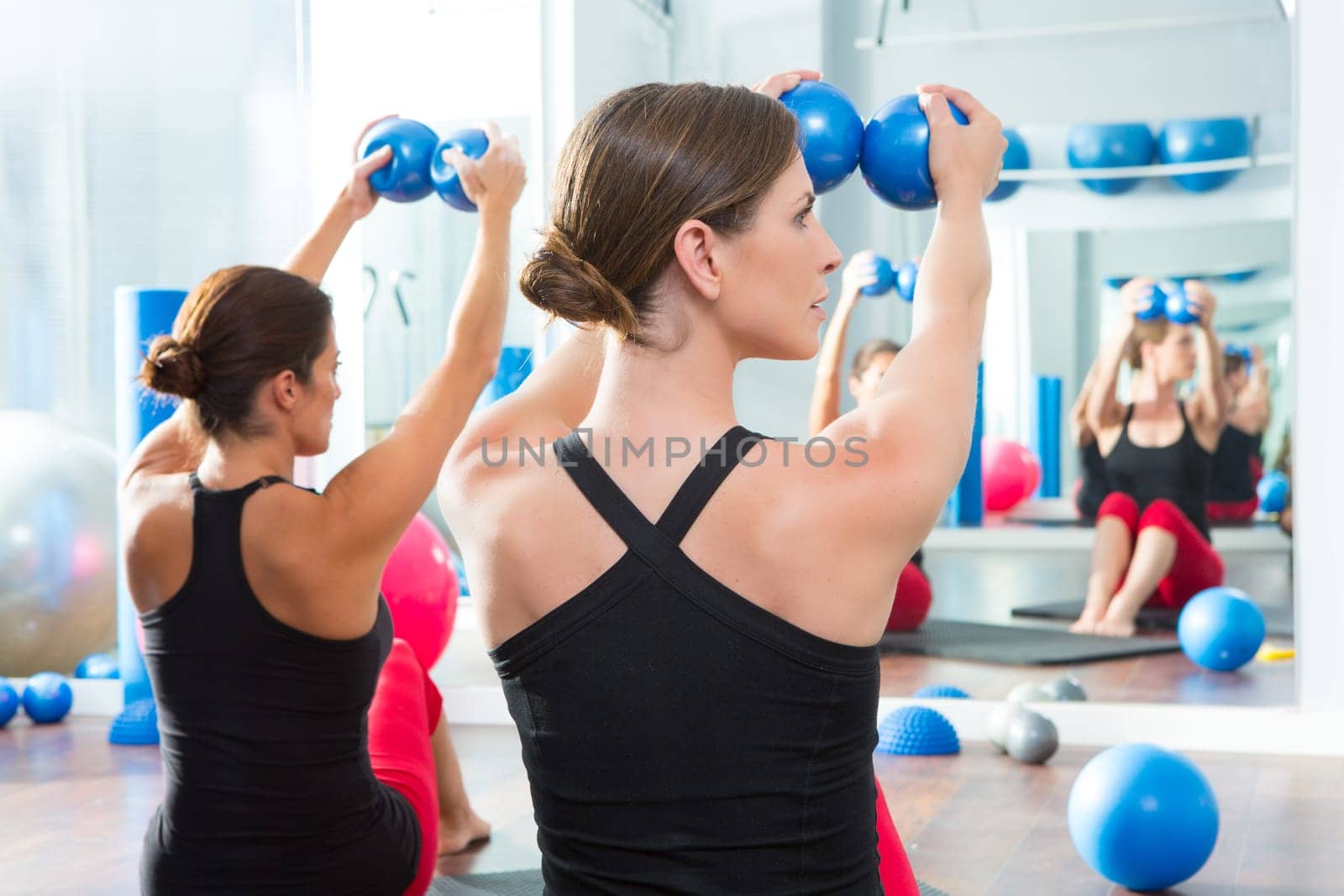 Pilates toning ball in women fitness class rear mirror view