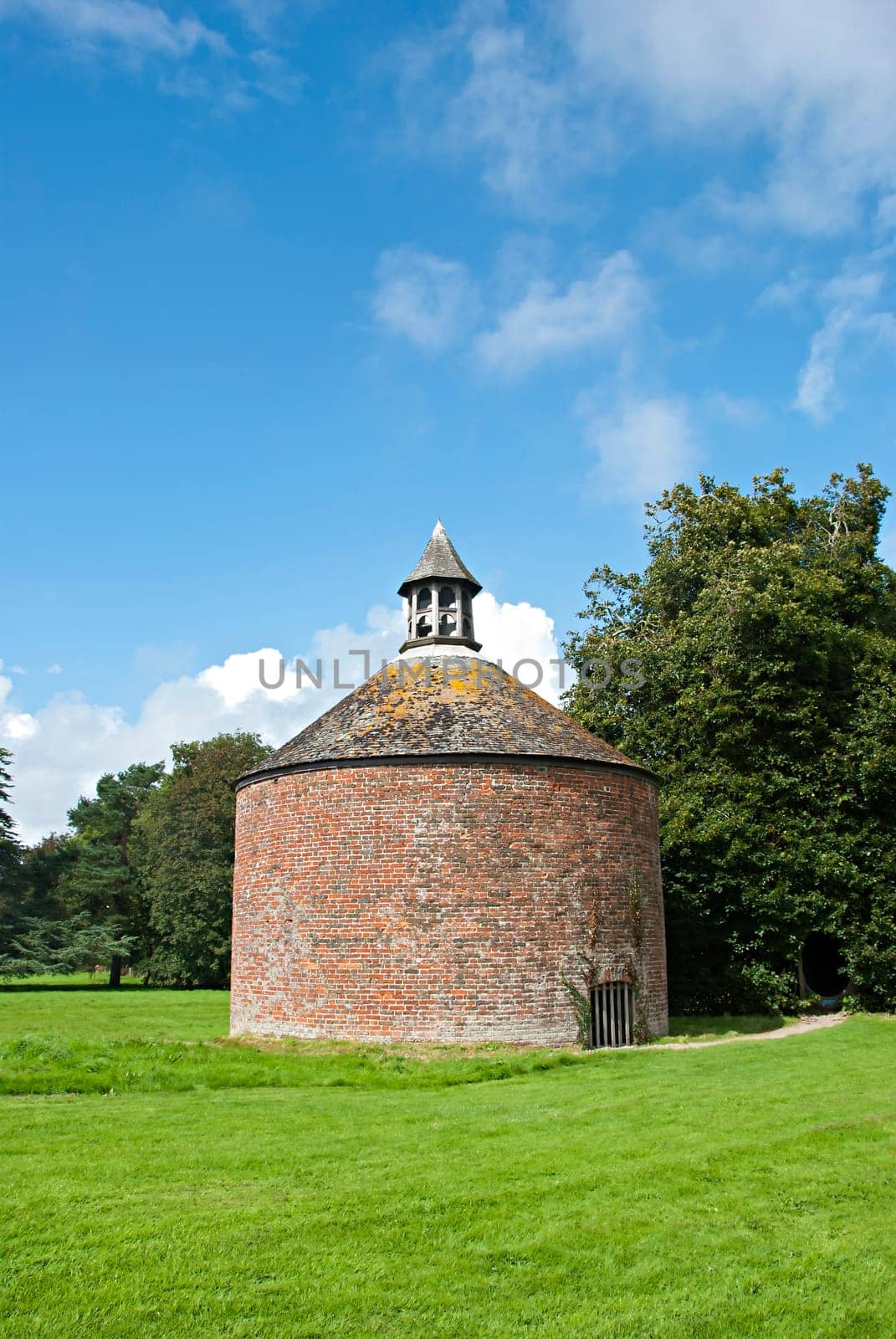 A vintage brick Dovecote under a blue sky