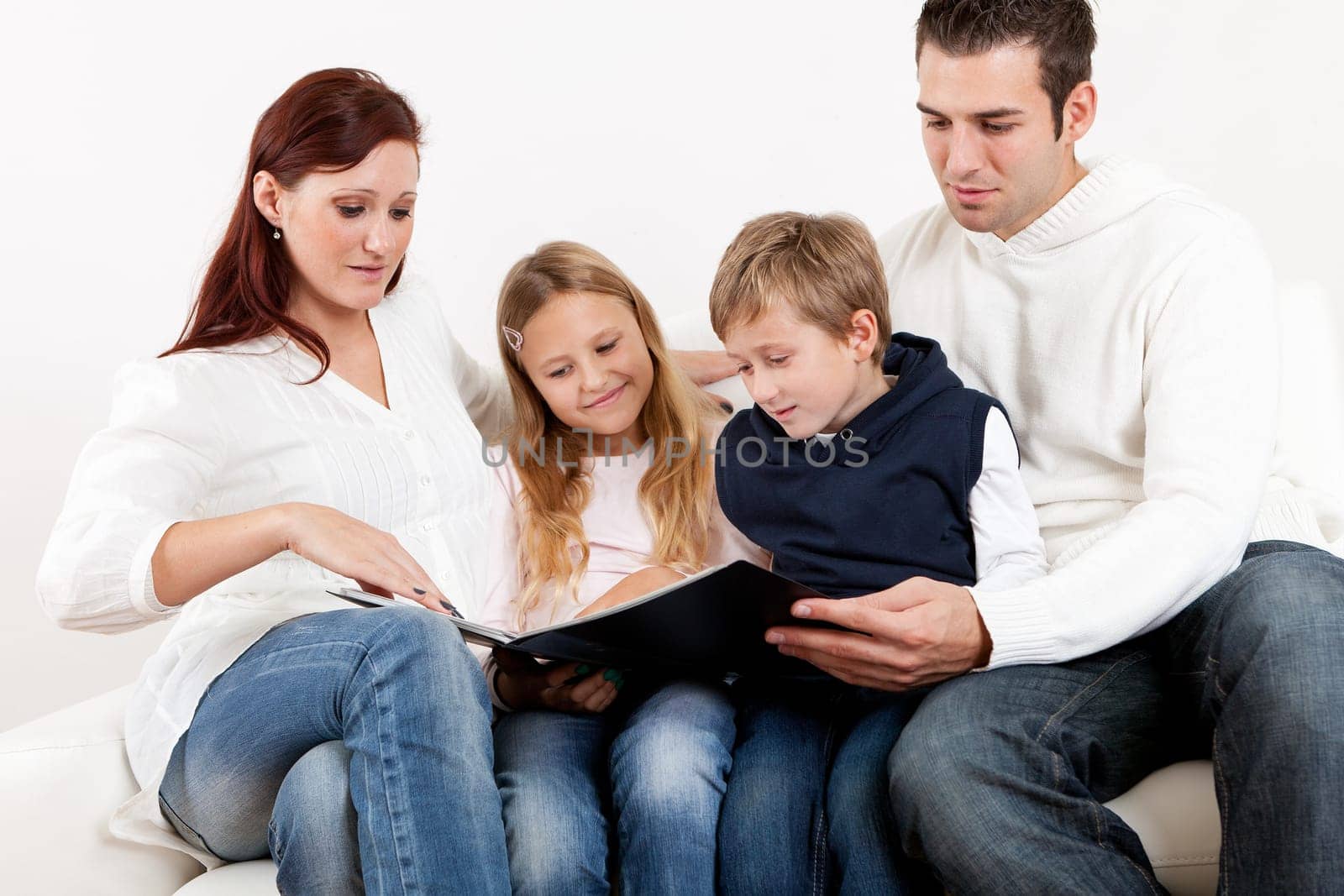 Hapy young family watching photo album at home