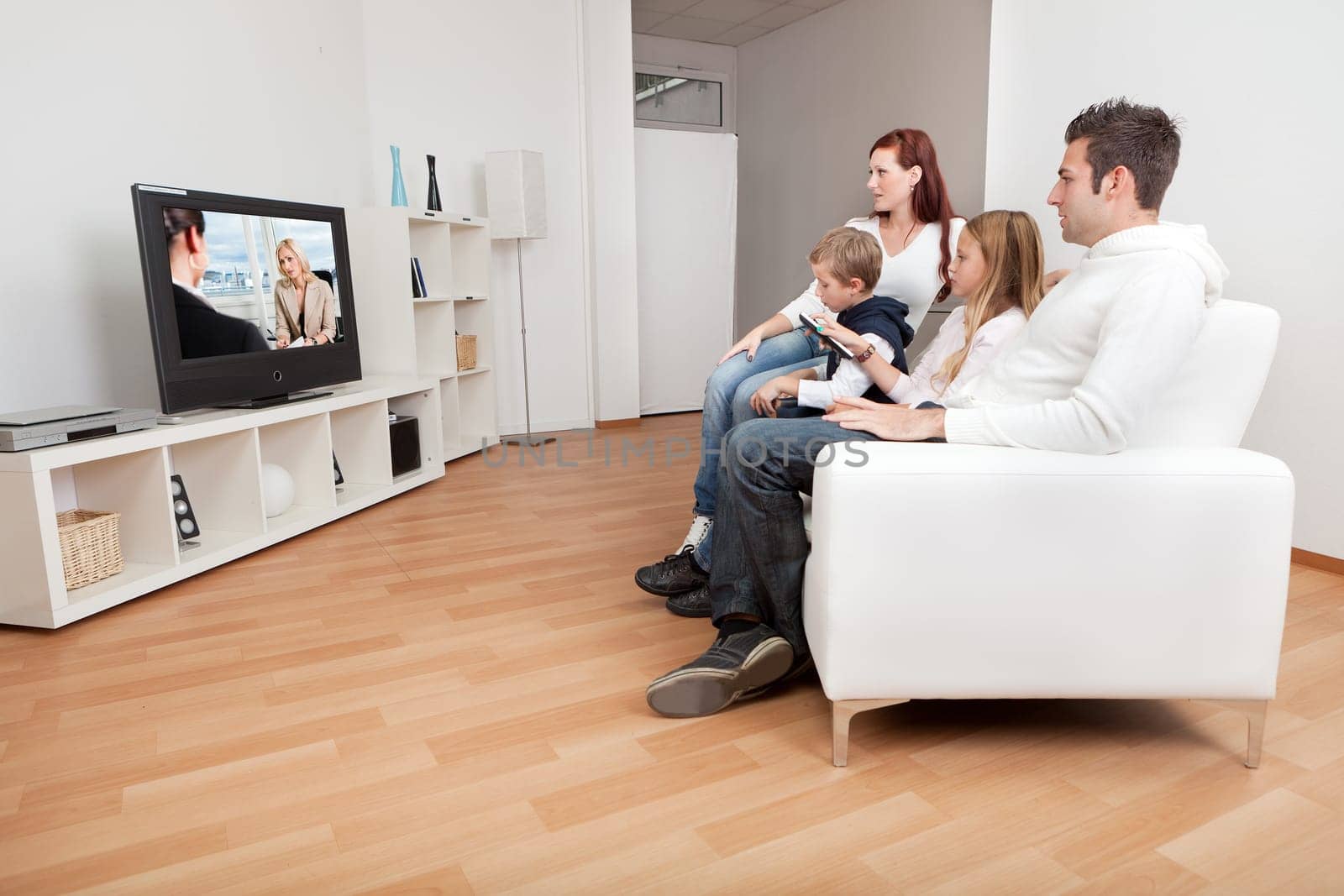 Young family watching TV together at home