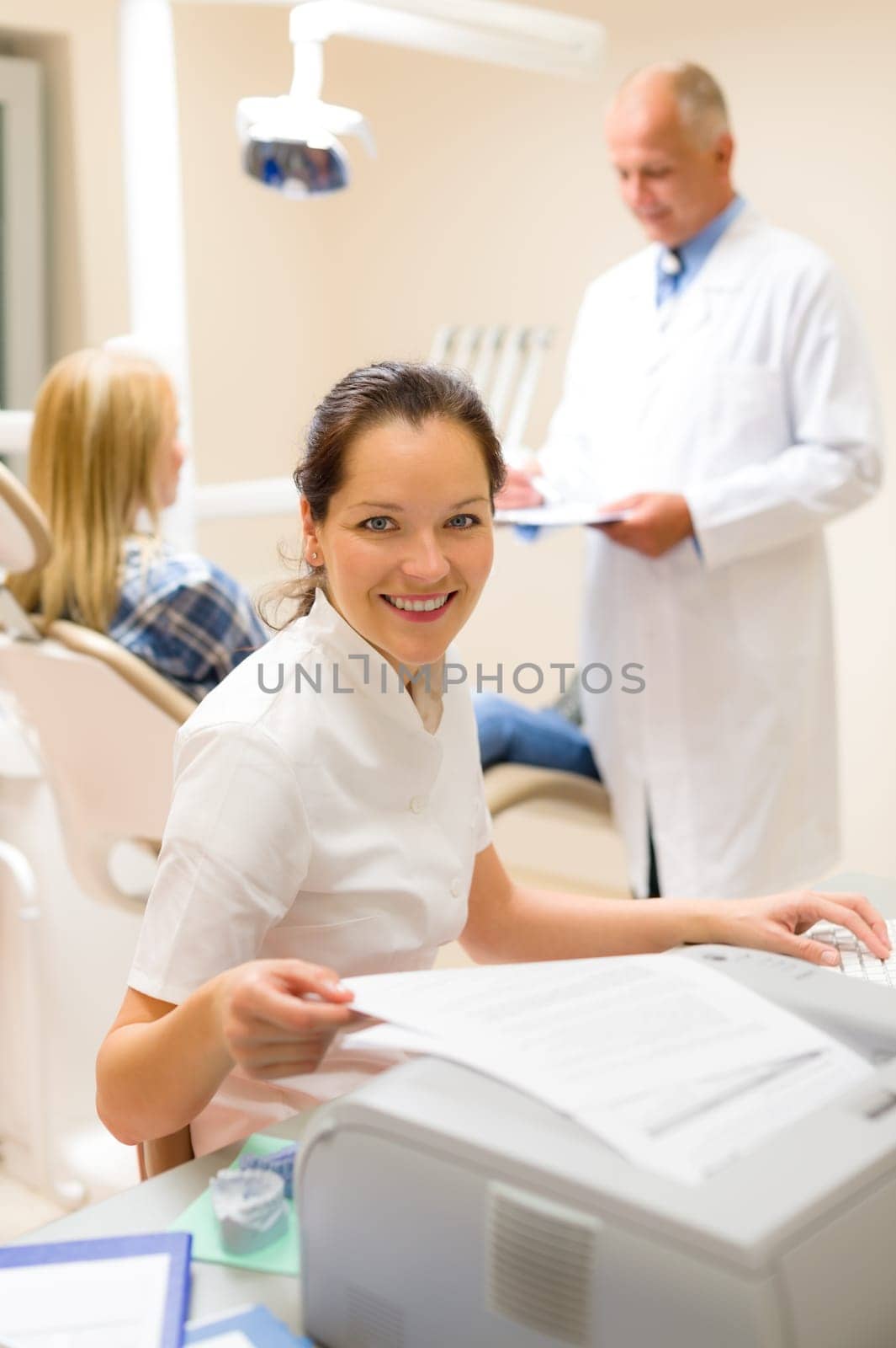 Dental assistant smiling woman prepare patient documentation stomatology clinic
