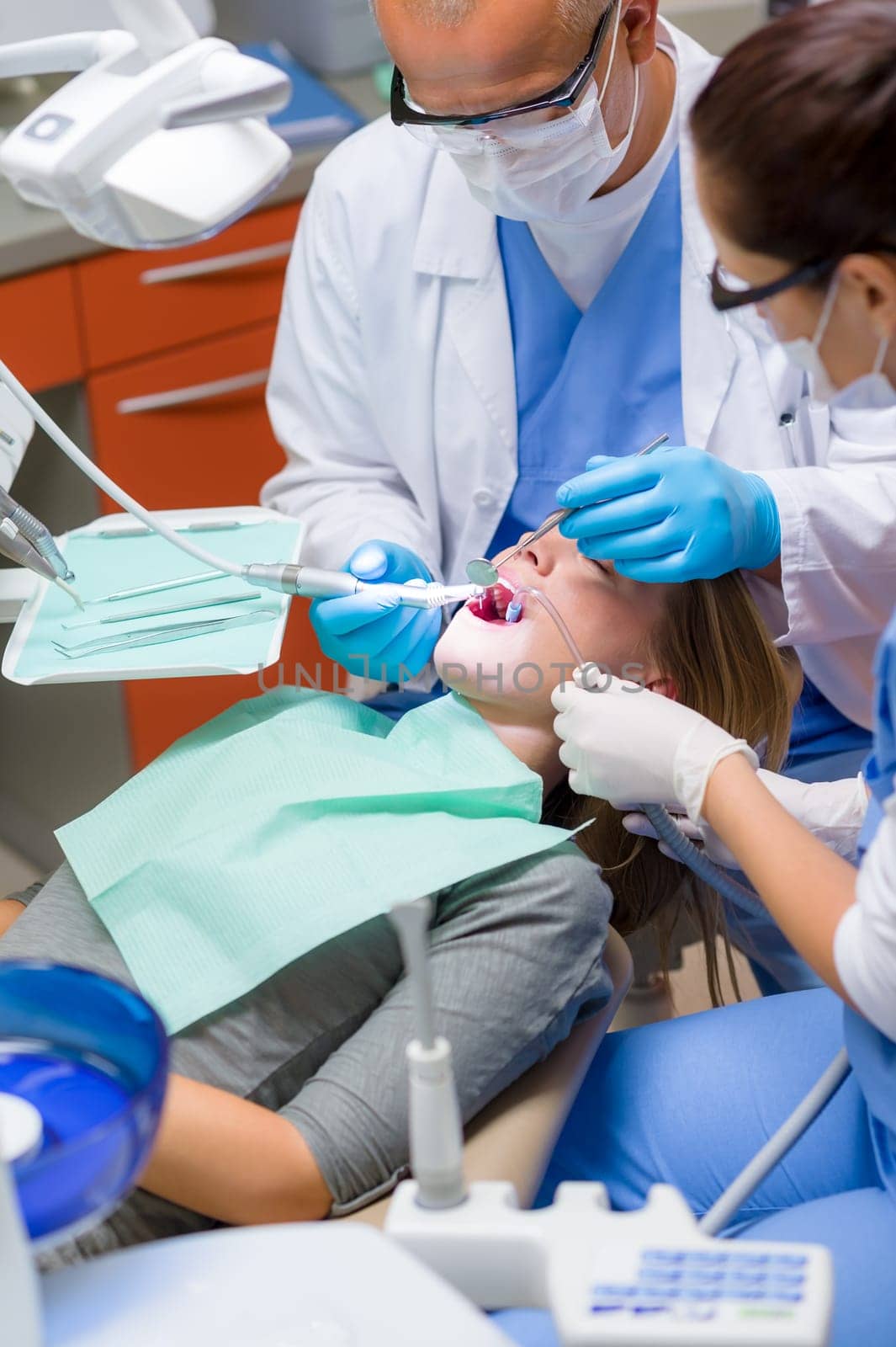 Woman at dentist surgery having dental checkup professional tools