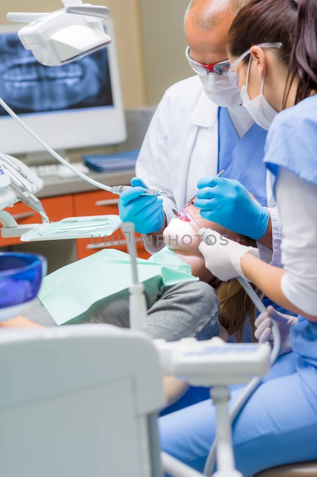 Woman at dentist surgery having dental checkup professional medical team