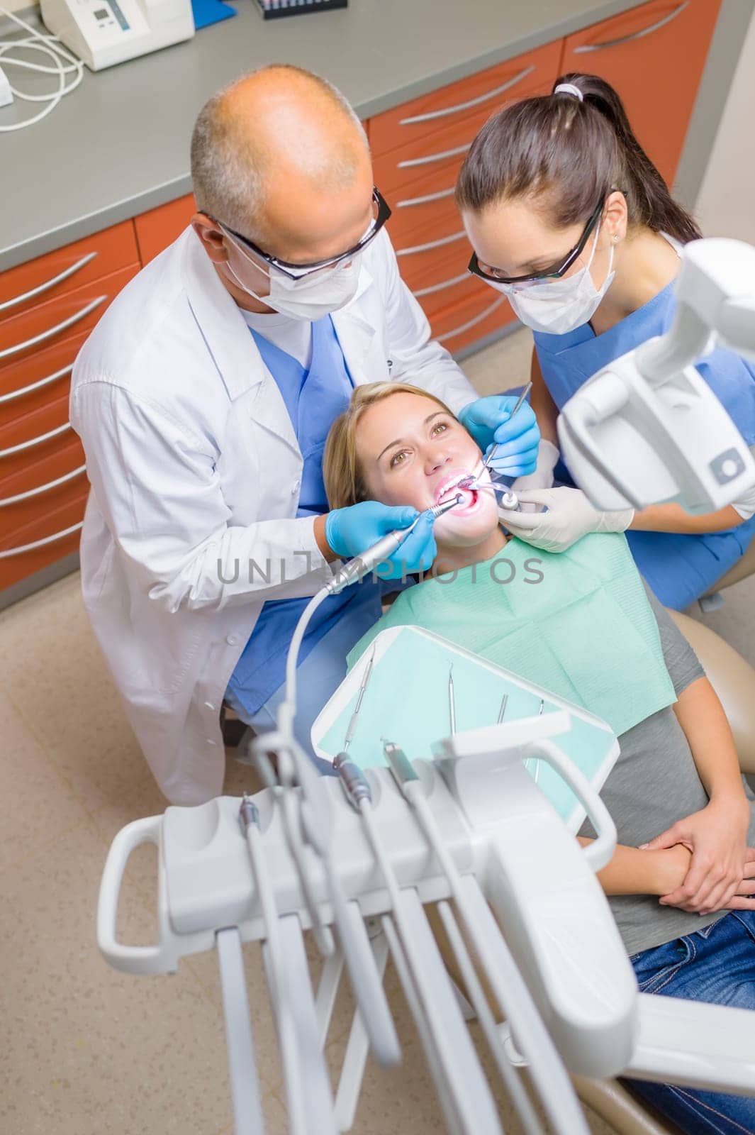 Professional dentist with nurse check patient teeth top view portrait