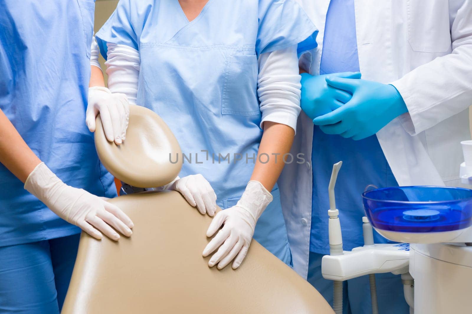 Dental chair surgery team standing around close-up ready for patient