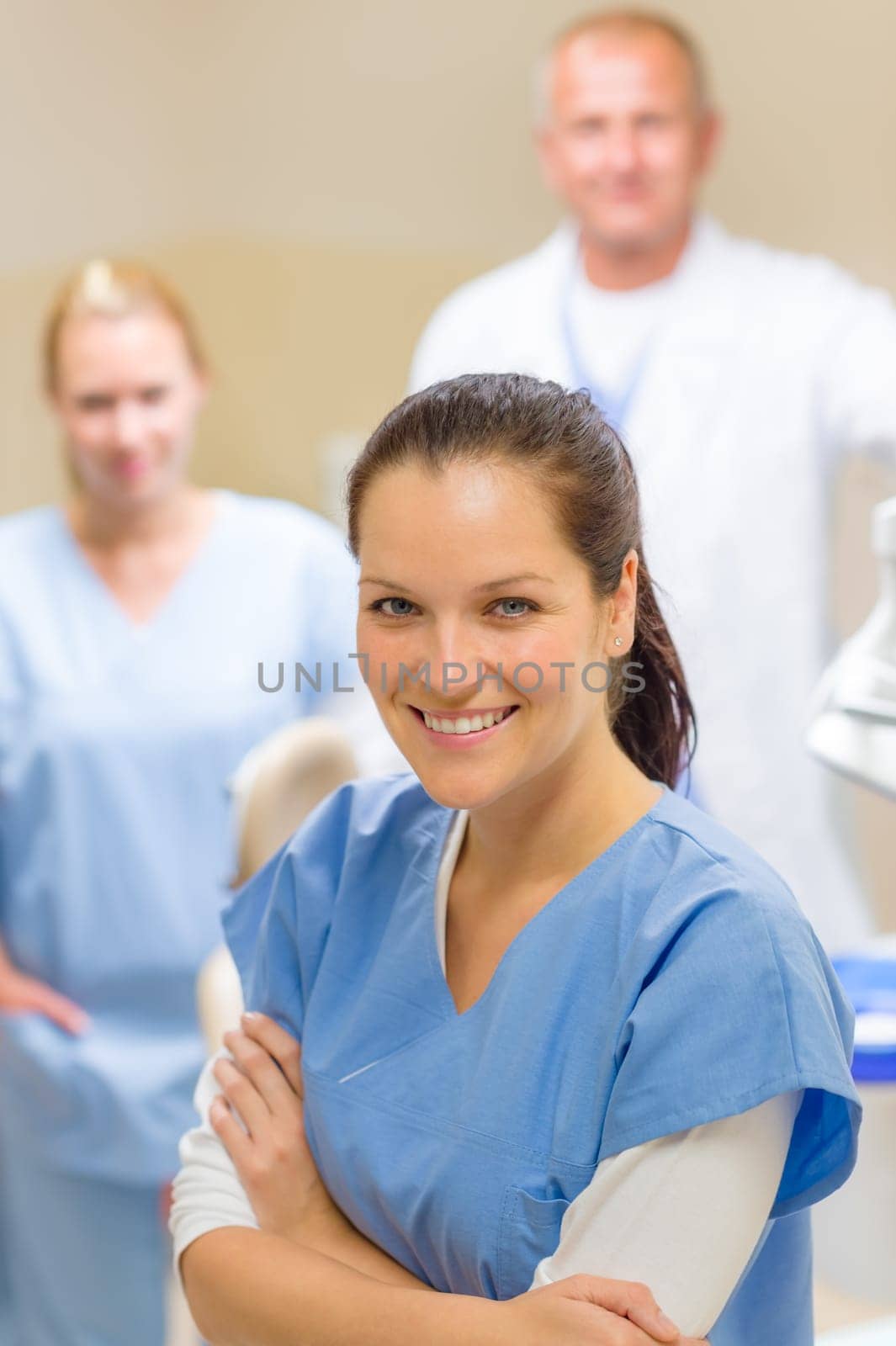 Smiling dental hygienist woman with stomatology team of medical professionals